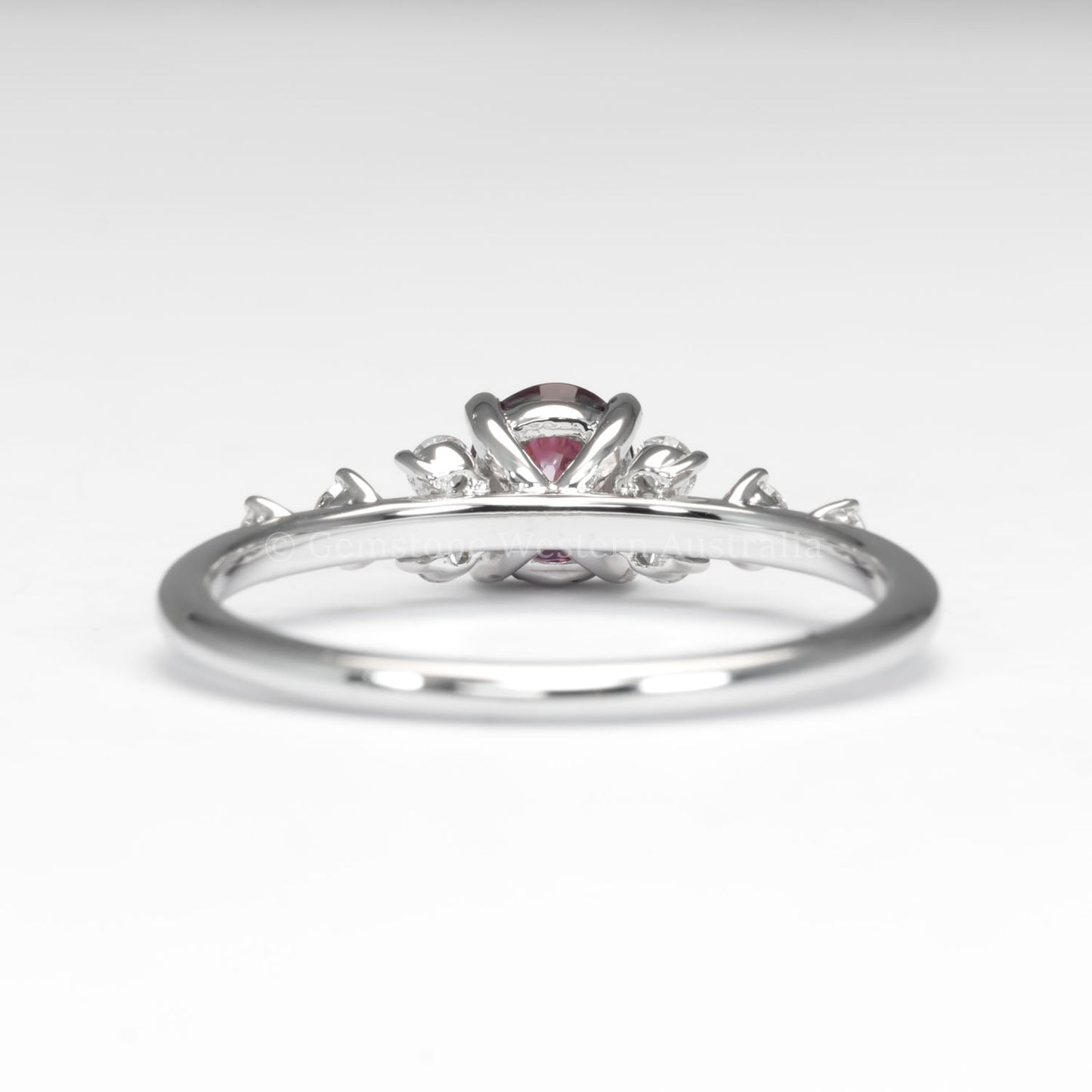 back view of natural ruby and diamond ring in platinum 950 in white background
