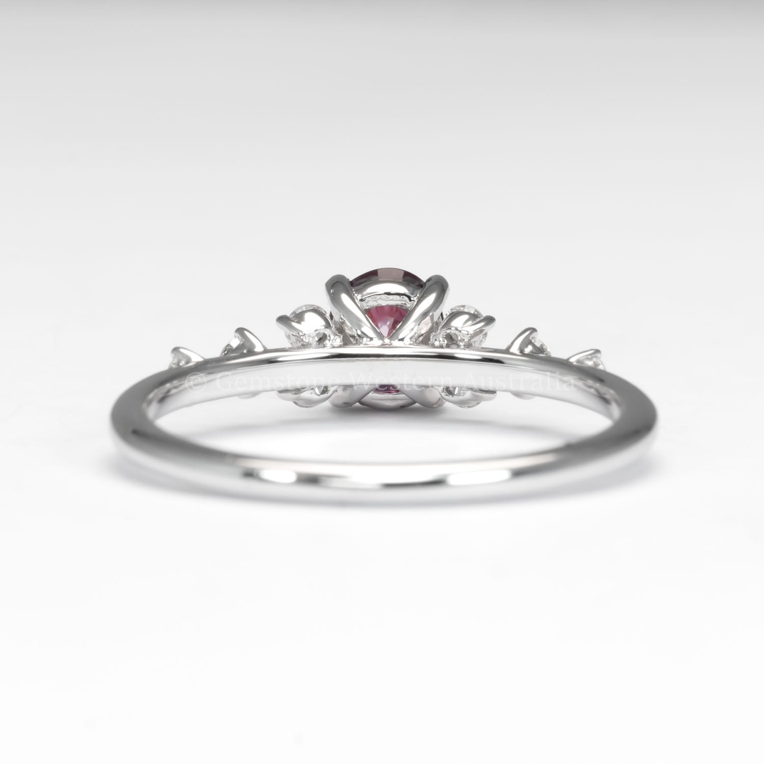 back view of natural ruby and diamond ring in platinum 950 in white background
