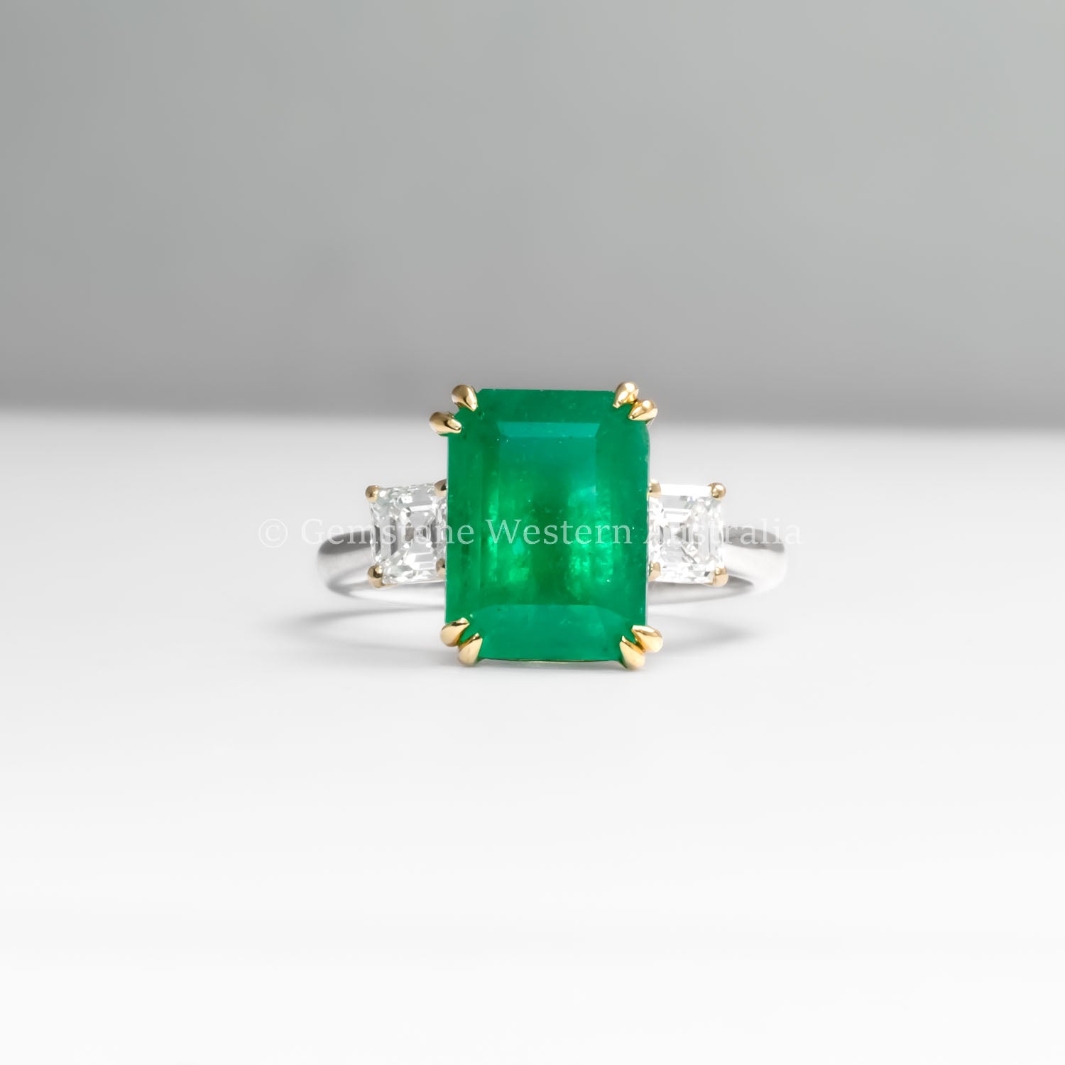 front view of Colombian Emerald and Diamond Ring in 18K Yellow Gold – East West Emerald Cut in neutral background