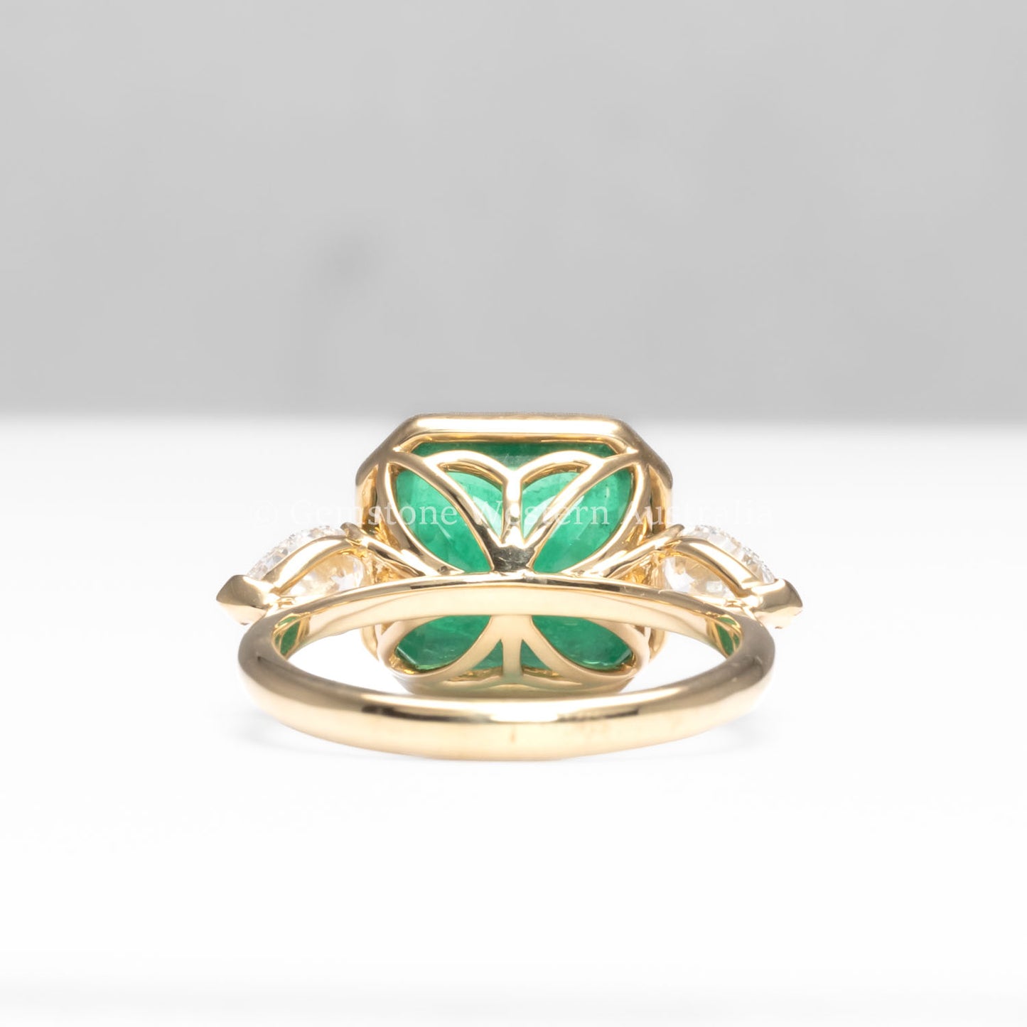 back view of Colombian Emerald and Diamond Ring in 18K Yellow Gold – East West Emerald Cut in white background