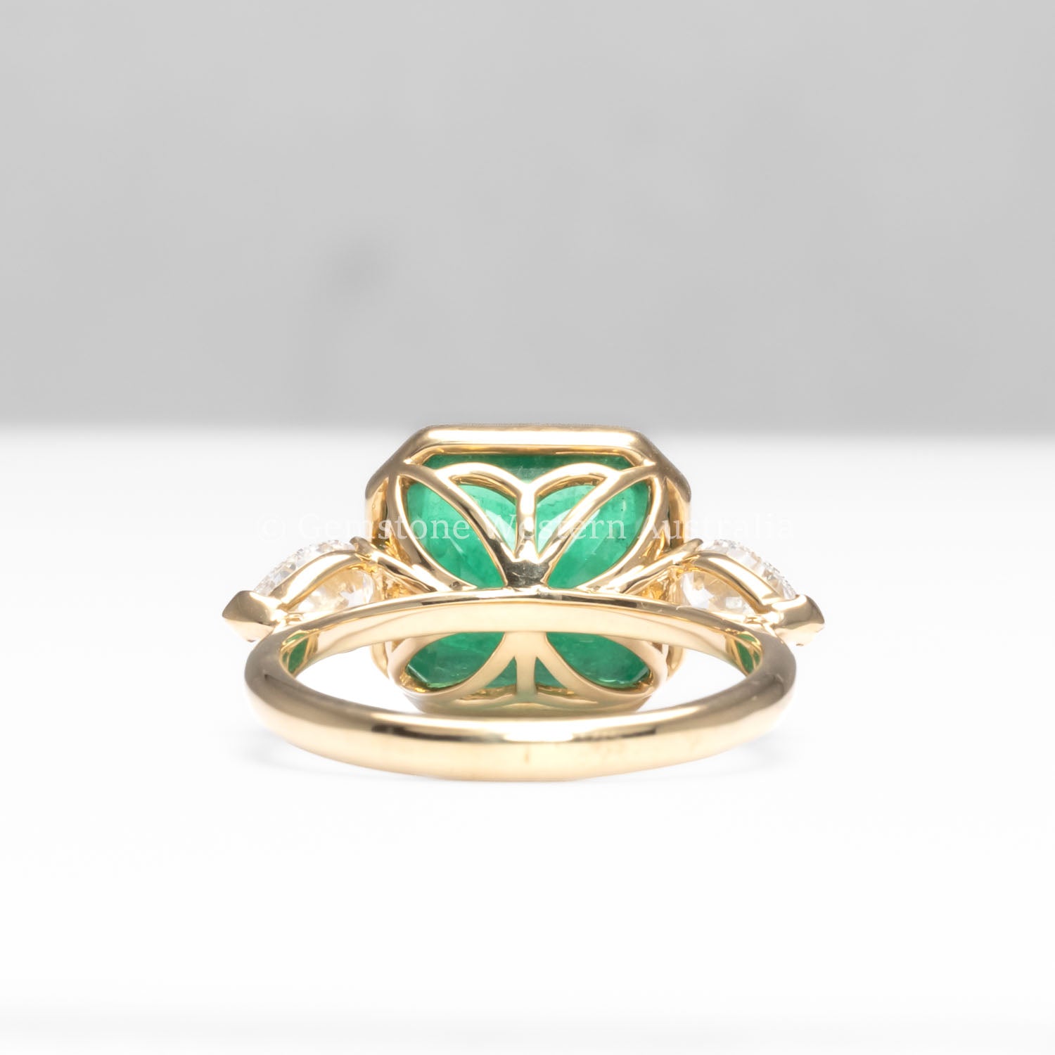 back view of Colombian Emerald and Diamond Ring in 18K Yellow Gold – East West Emerald Cut in white background