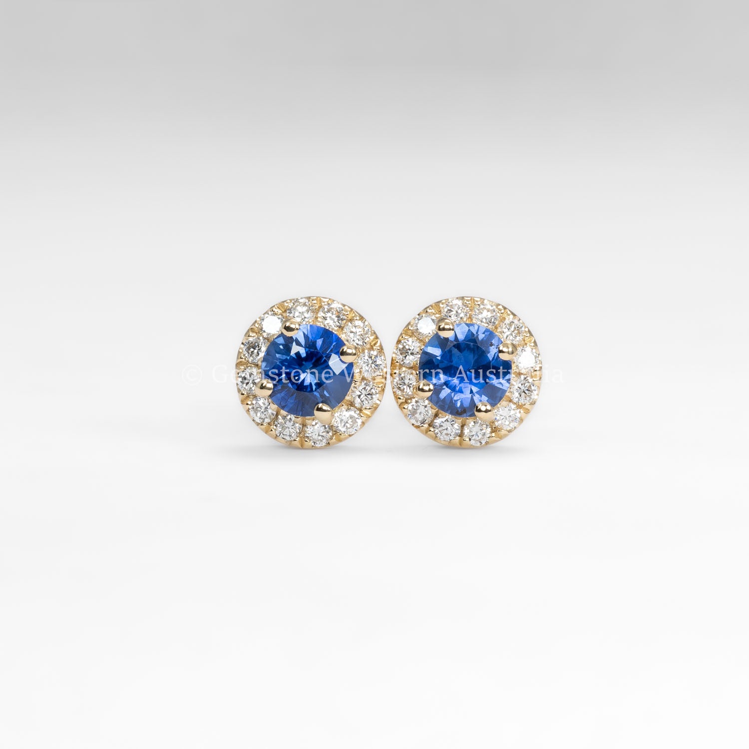 front view of Blue Sapphire and Diamond Halo Stud Earrings in 18K Yellow Gold in neutral background