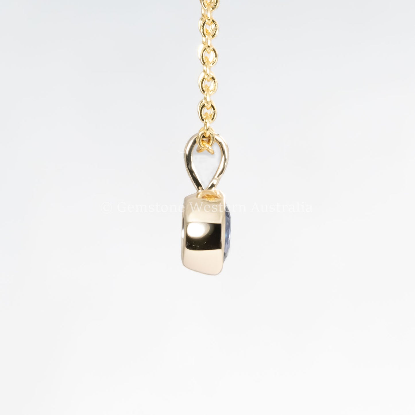side view of Royal Blue Sapphire Pendant in 18K Yellow Gold in neutral background