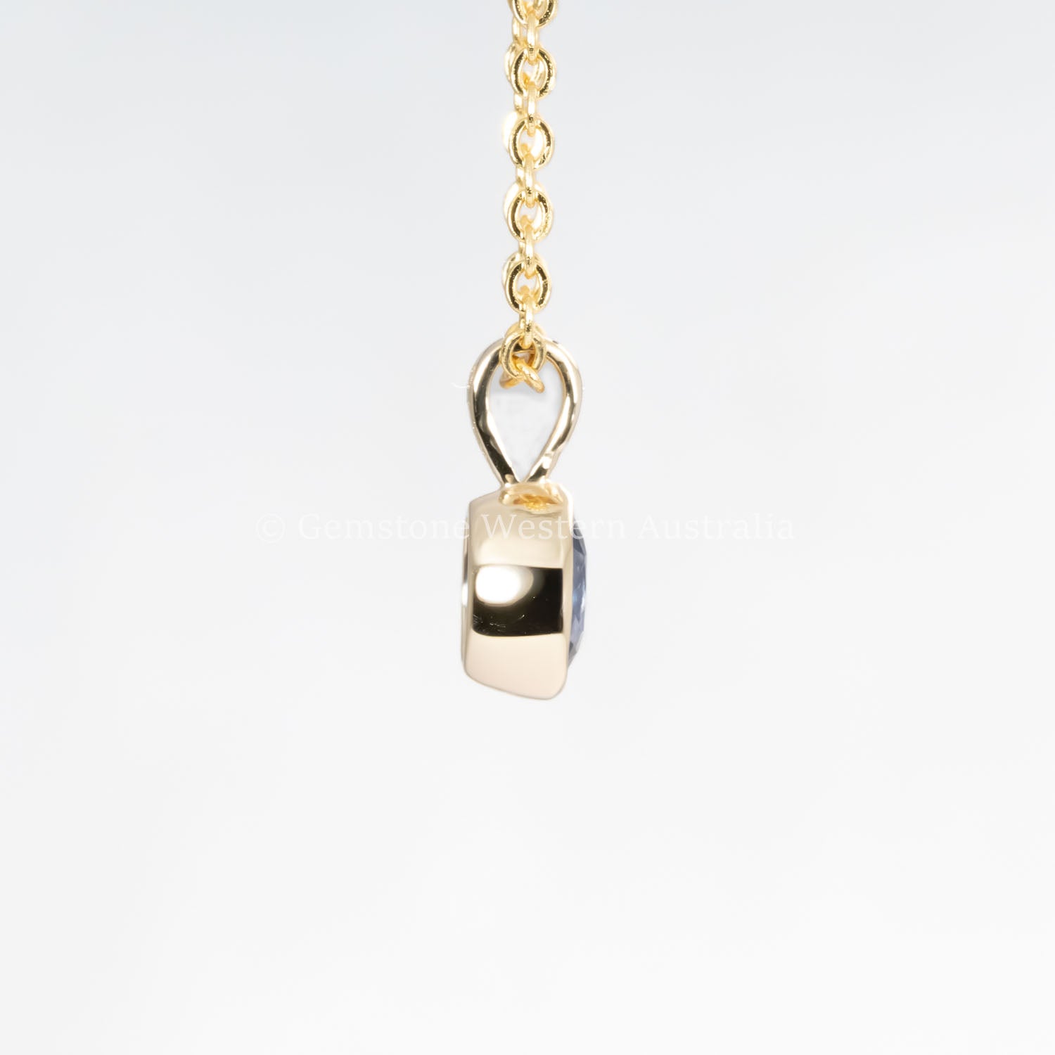 side view of Royal Blue Sapphire Pendant in 18K Yellow Gold in neutral background