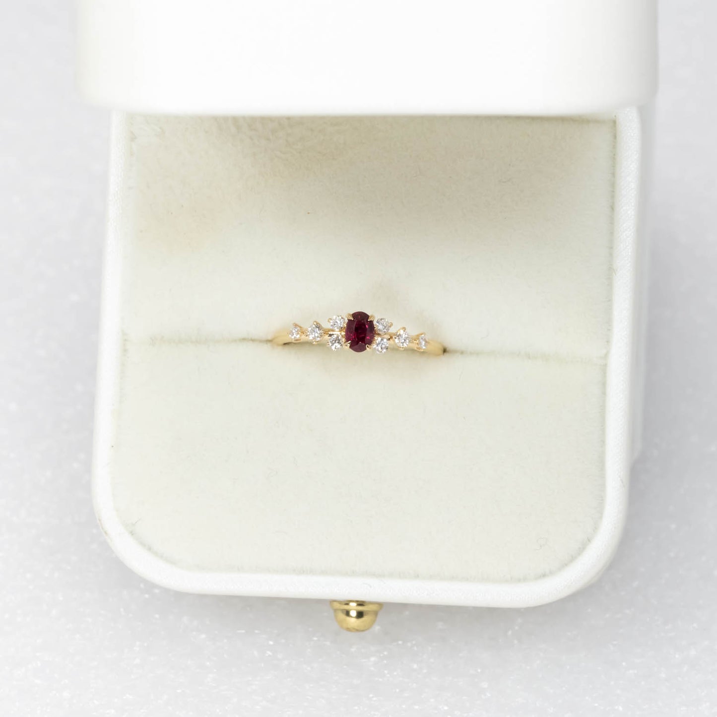 view of a Natural Ruby & Diamond Ring in 18K Yellow Gold ina rig box in neutral background