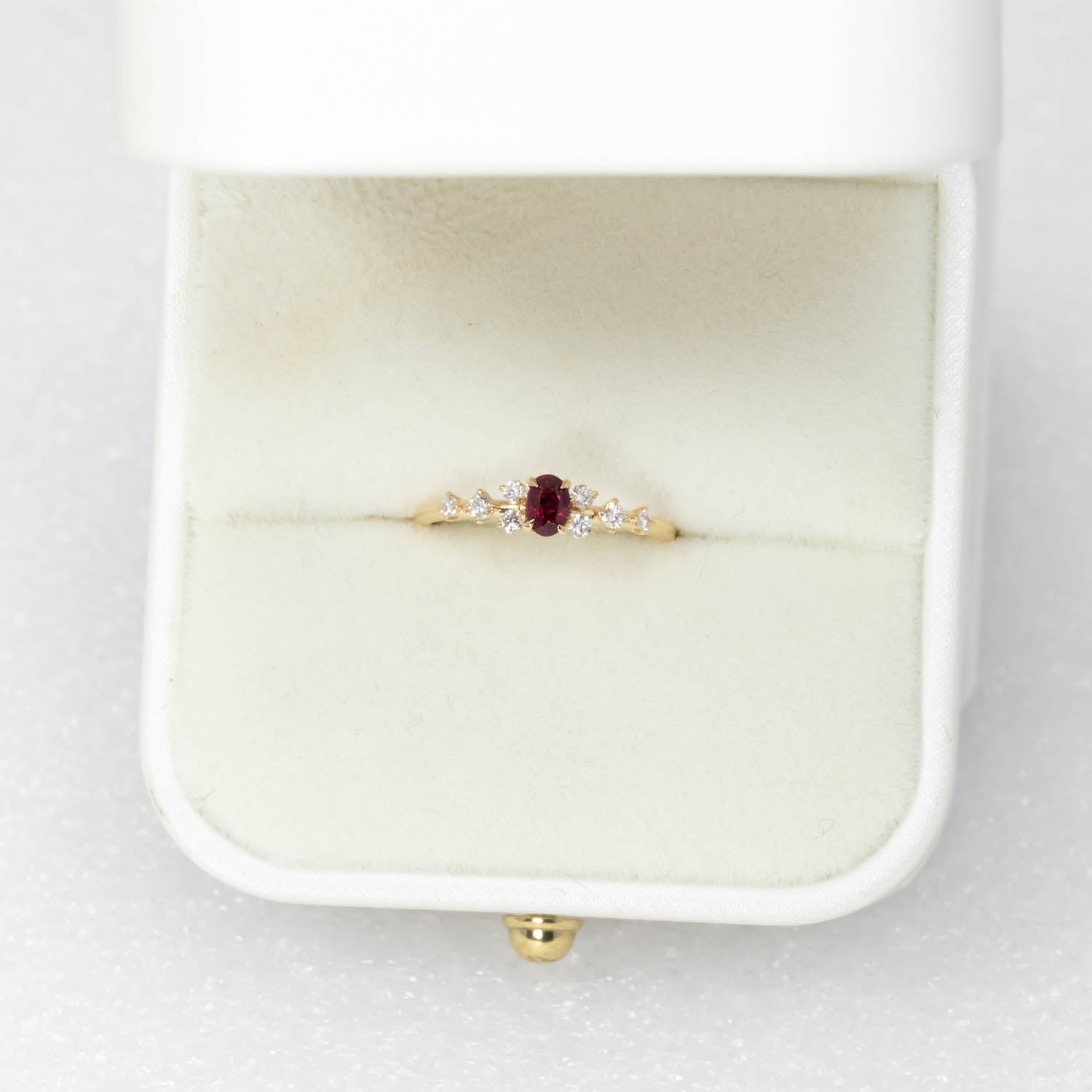 view of a Natural Ruby & Diamond Ring in 18K Yellow Gold ina rig box in neutral background