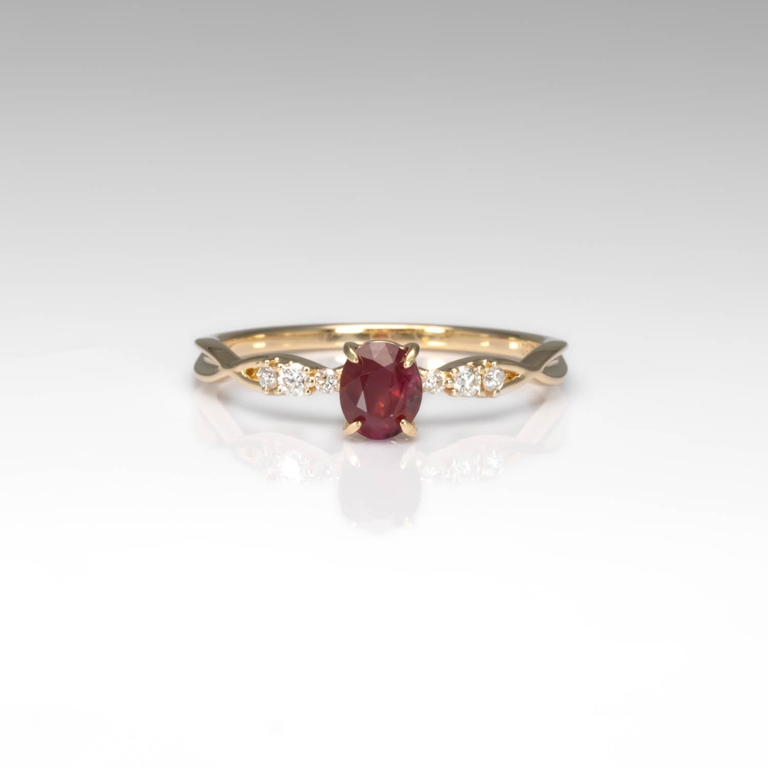 front view of a Natural Ruby & Diamond Twisted Band Ring in 18K Yellow Gold in neutral background
