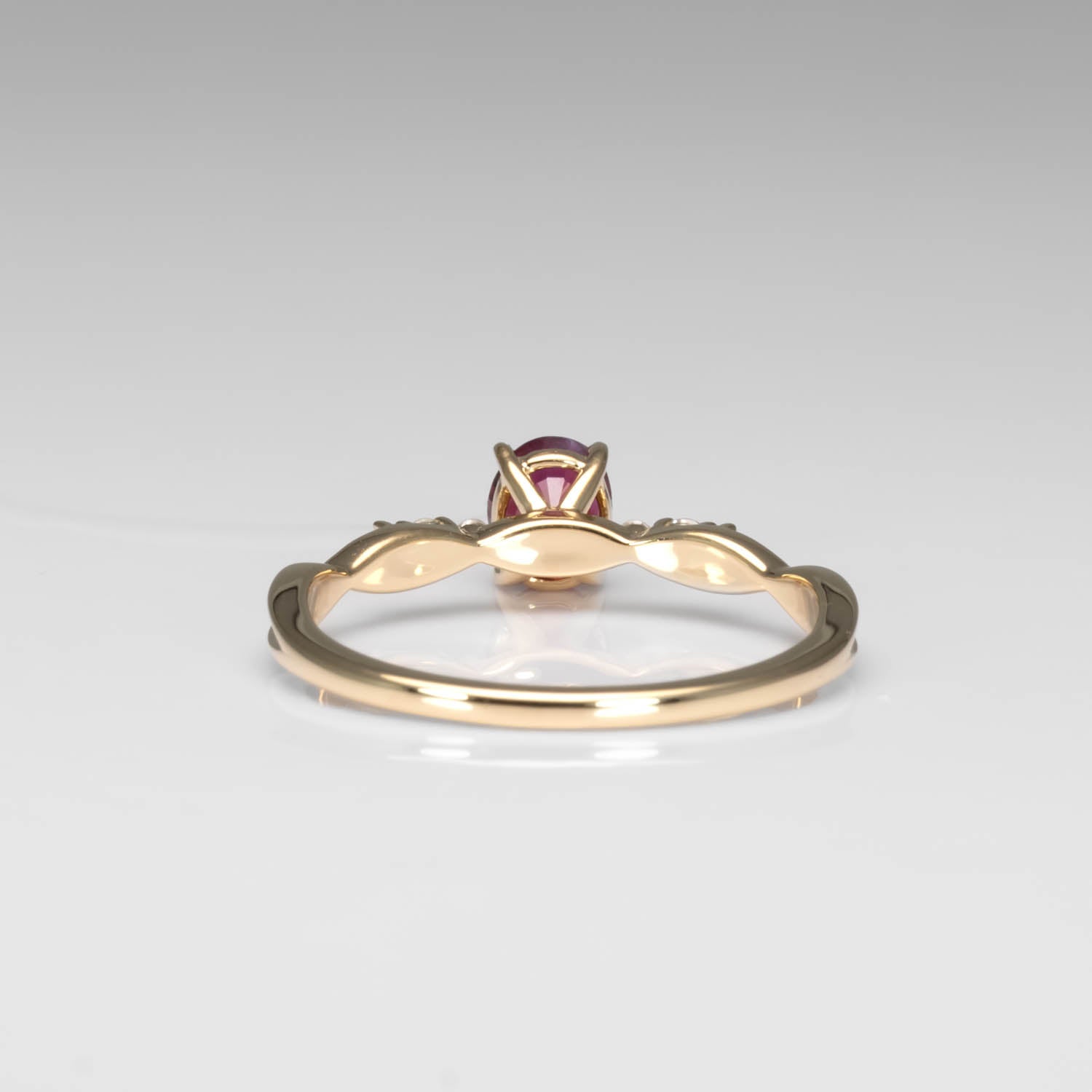 back view of a Natural Ruby & Diamond Twisted Band Ring in 18K Yellow Gold in a ring box in neutral background