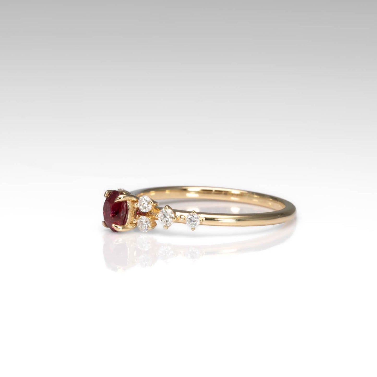 side view of a Natural Ruby & Diamond Ring in 18K Yellow Gold in neutral background