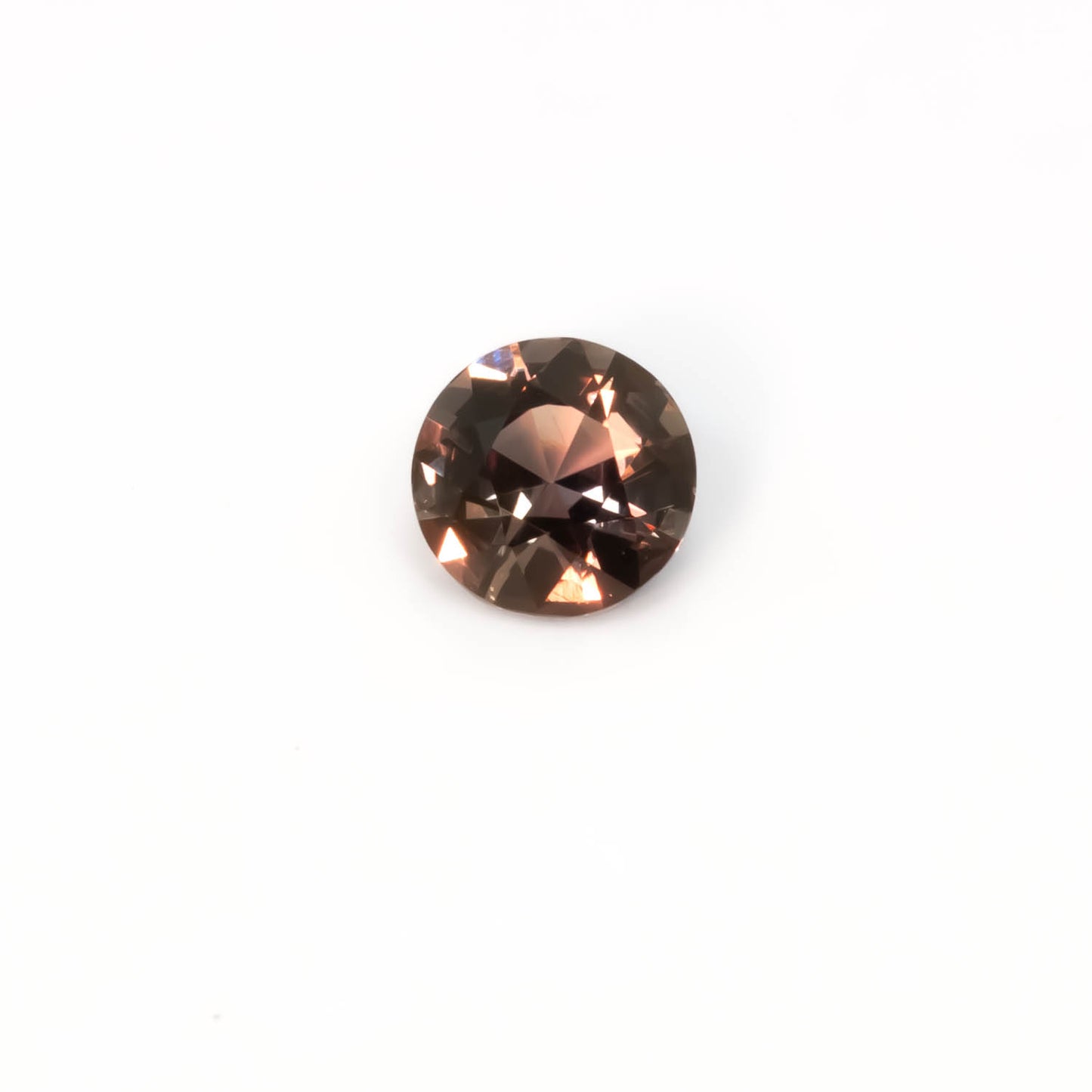 second view of 1.03CT Natural Unheated Colour Change Sapphire – Brown to Red Round Mixed Cut displaying warmer tones