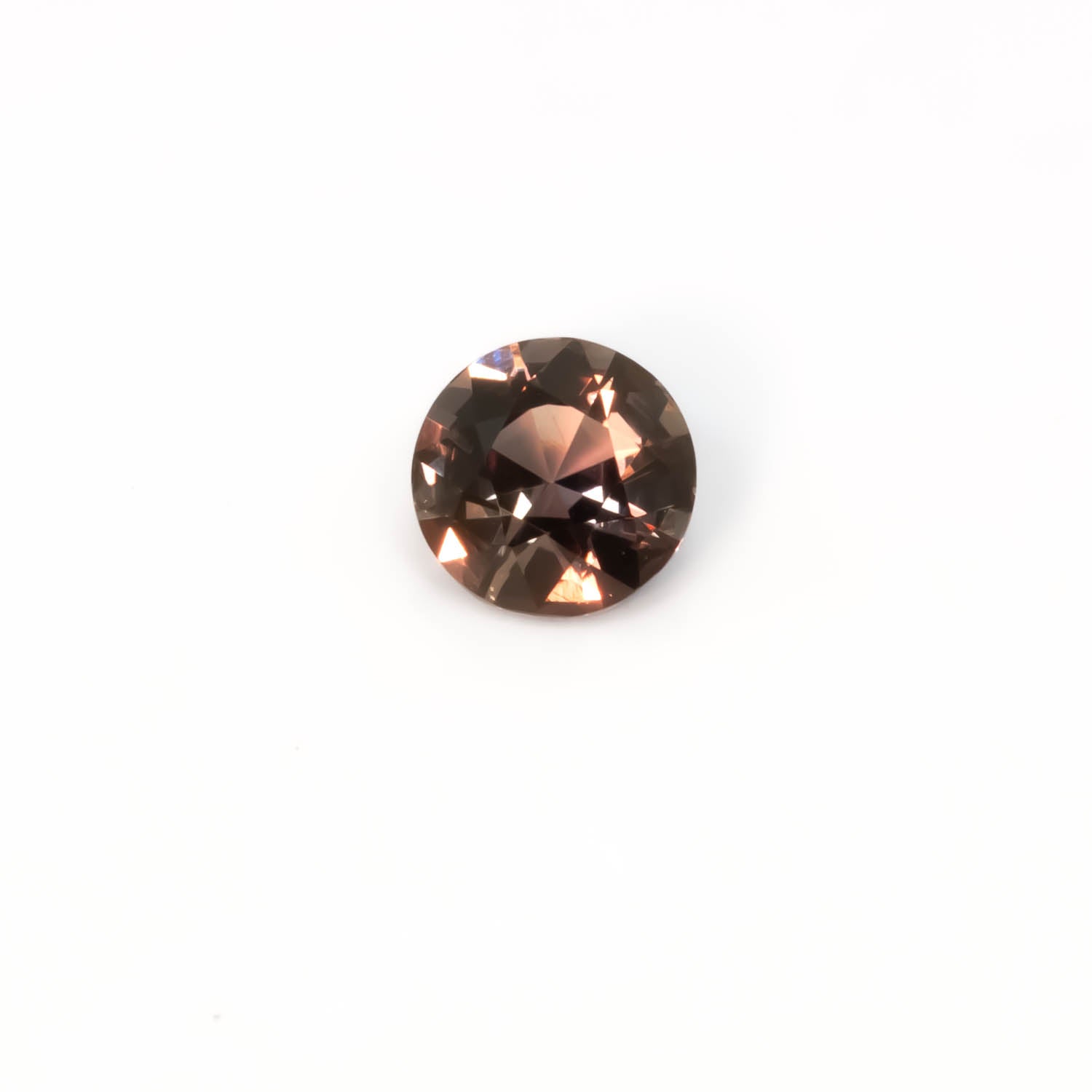 second view of 1.03CT Natural Unheated Colour Change Sapphire – Brown to Red Round Mixed Cut displaying warmer tones