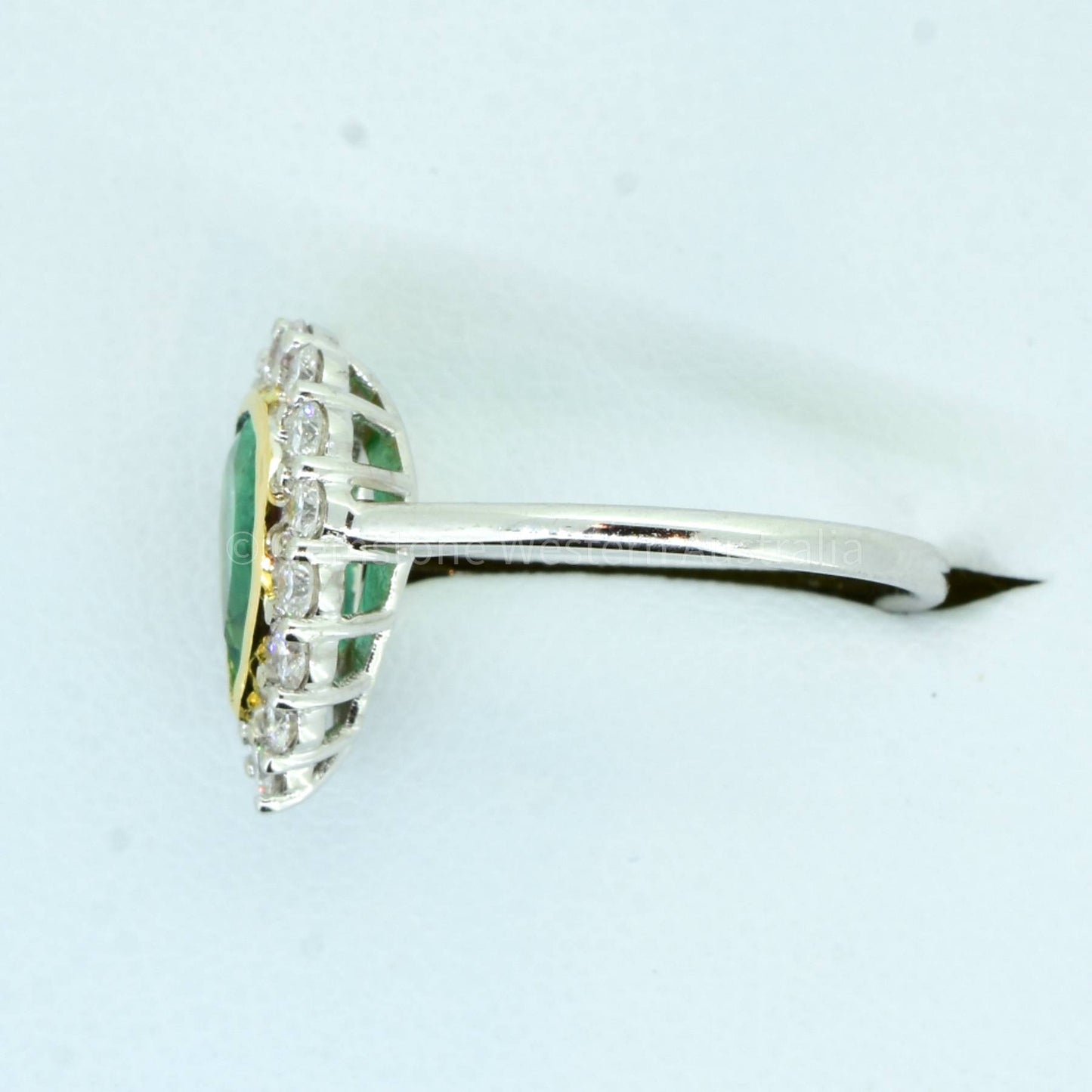 Bezel Set Emerald in a Diamond Halo Ring in 18K Gold