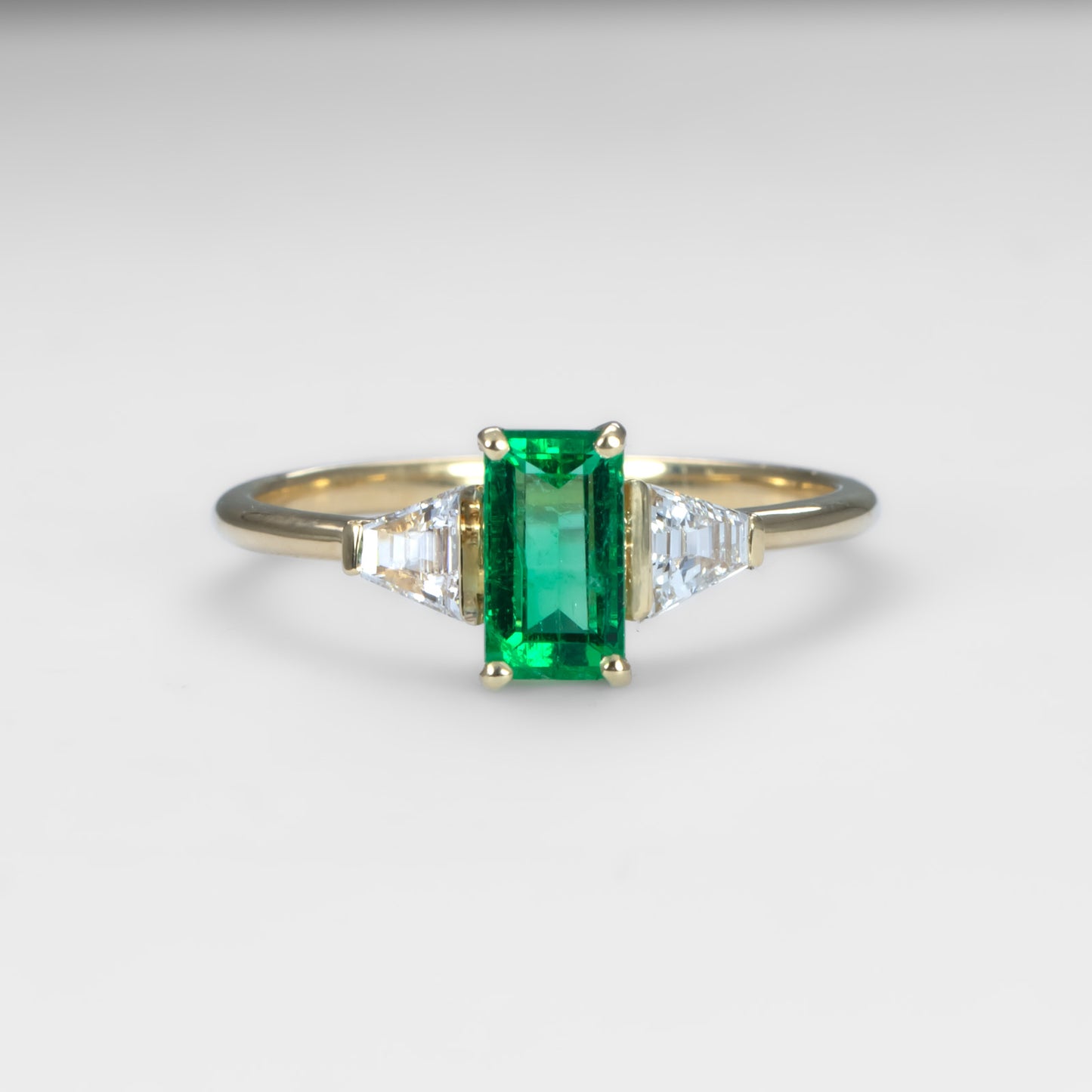 Elongated Emerald Cut Ring with Colombian Emerald and Trapezoid Diamonds in 18K Yellow Gold