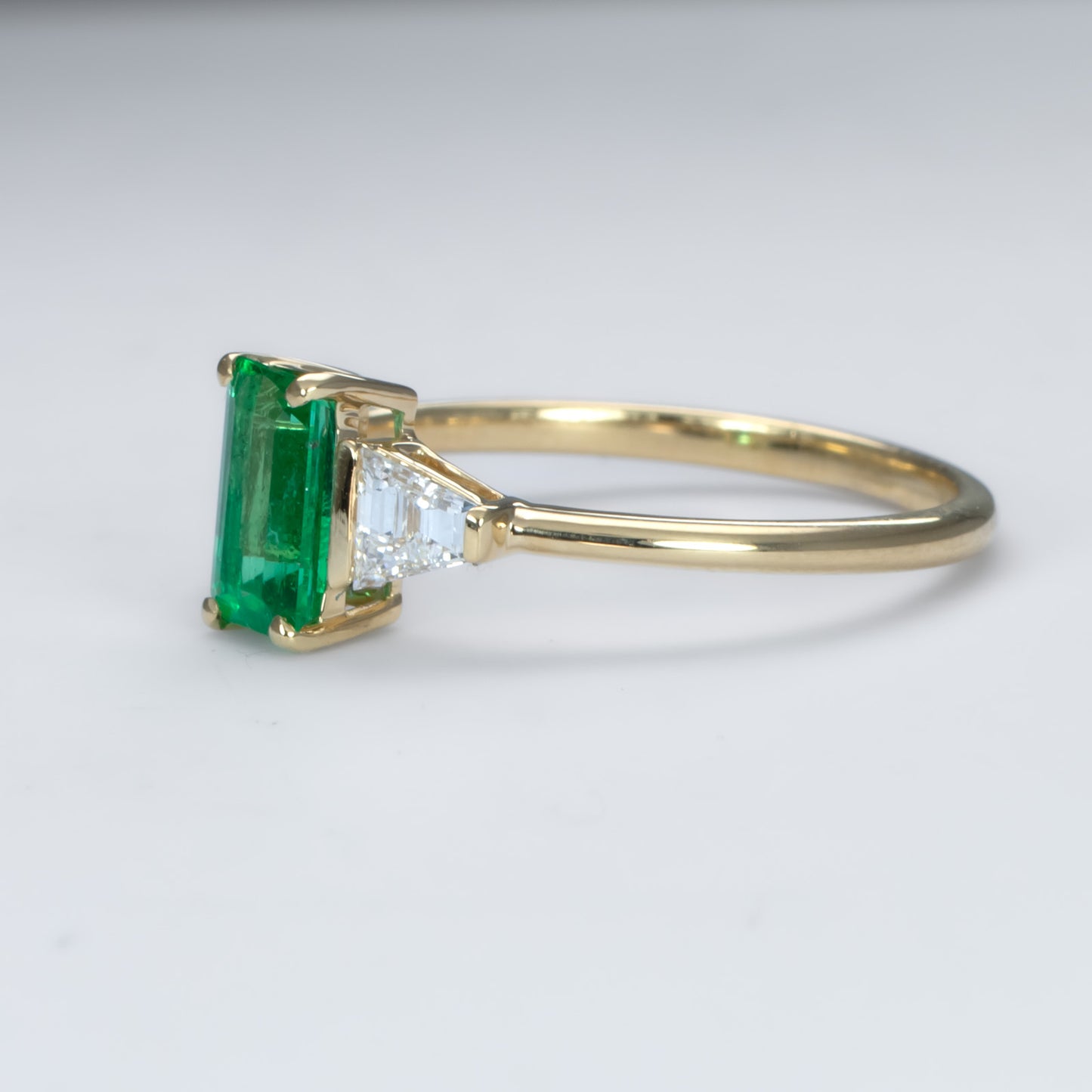 Elongated Emerald Cut Ring with Colombian Emerald and Trapezoid Diamonds in 18K Yellow Gold