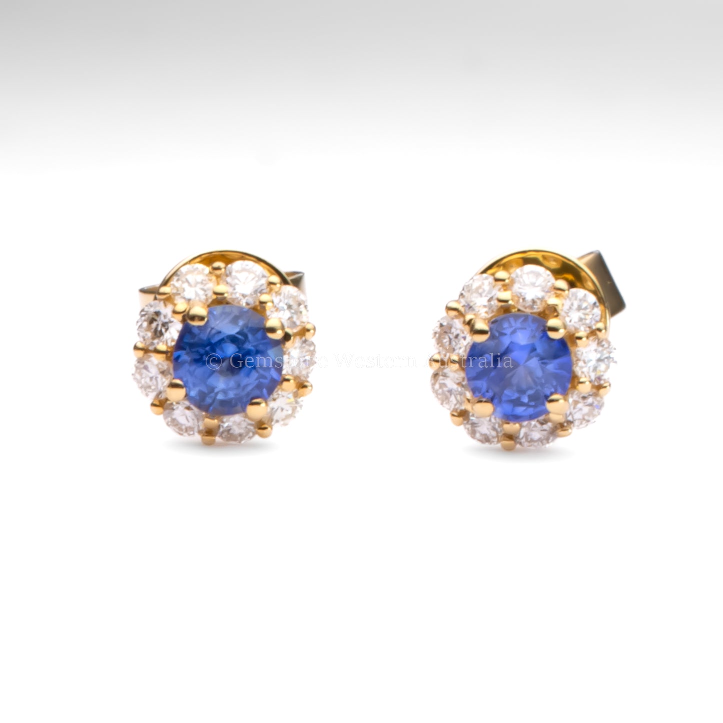 Pair of earrings with blue gemstones and gold accents on a white background
