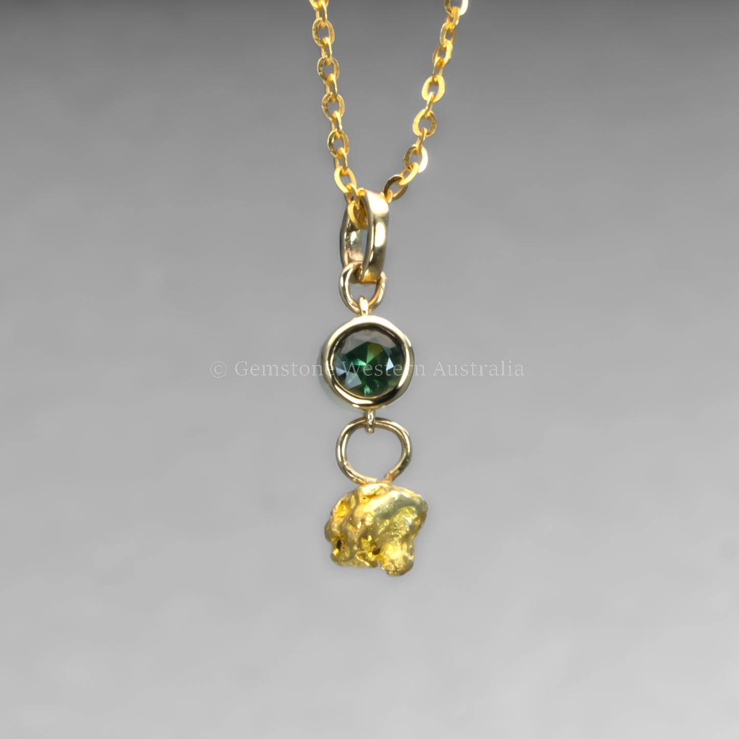 sapphire and gold nugget pendant in grey backgroun
