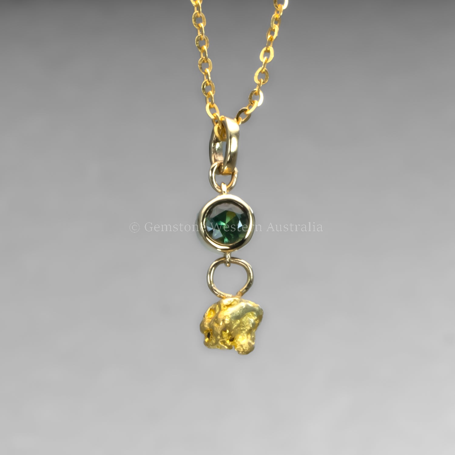 sapphire and gold nugget pendant in grey backgroun