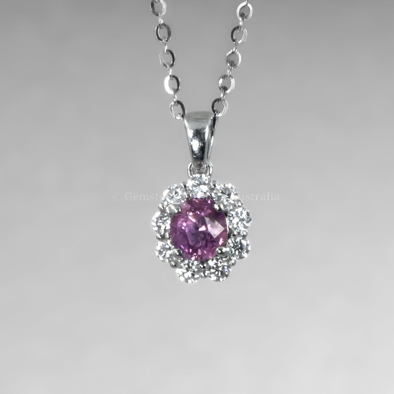 Platinum necklace with a pink sapphire pendant on a gray background