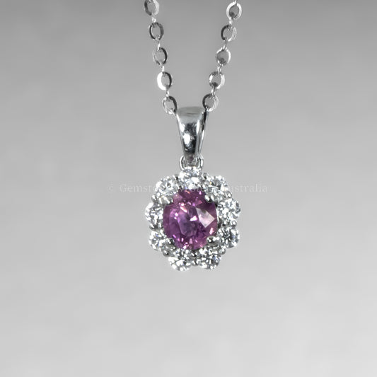 Platinum necklace with a pink sapphire pendant on a gray background