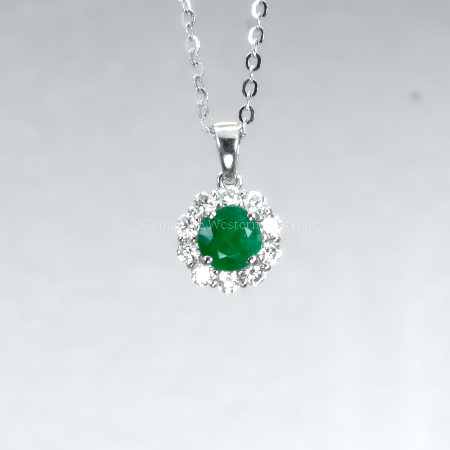 Colombian emerald pendant on grey background 