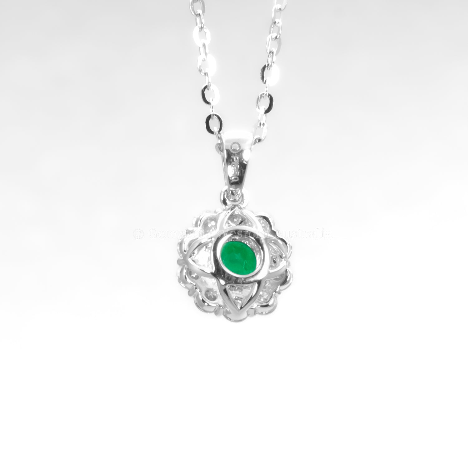 back view of Colombian emerald pendant on grey background 