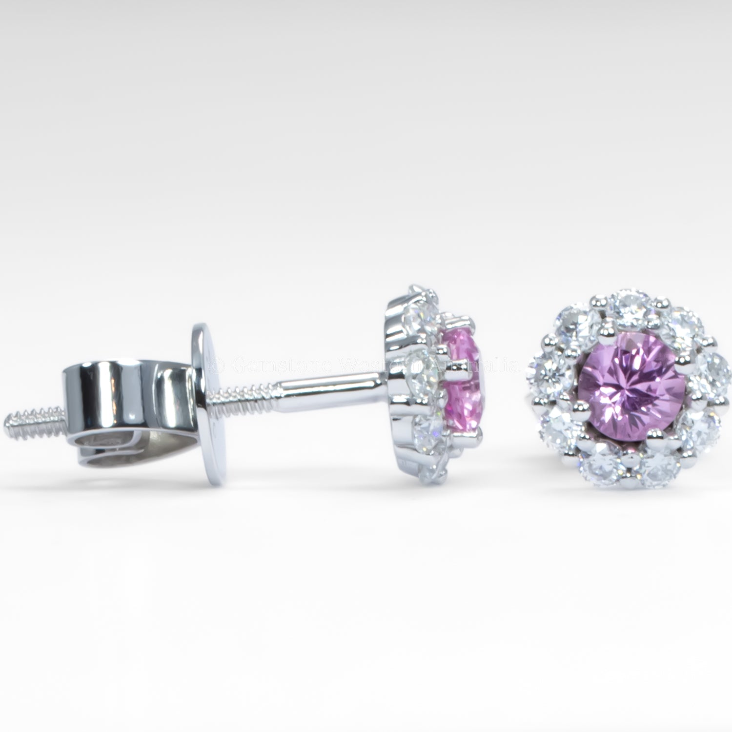contrast of side and front view of a pair of earrings with pink sapphires and diamond-like stones on a light gray background