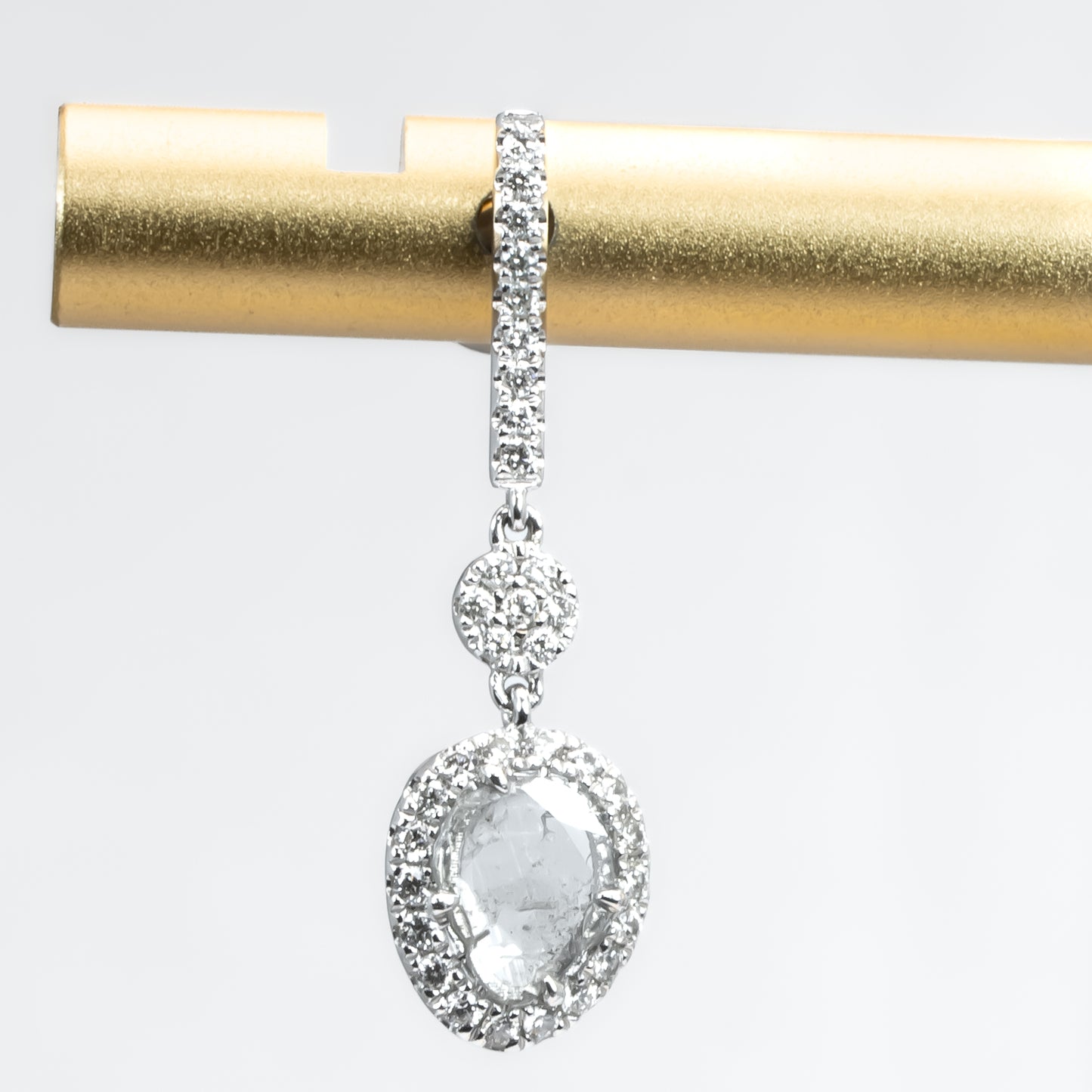 close up view of salt and pepper diamond slice earrings on white background