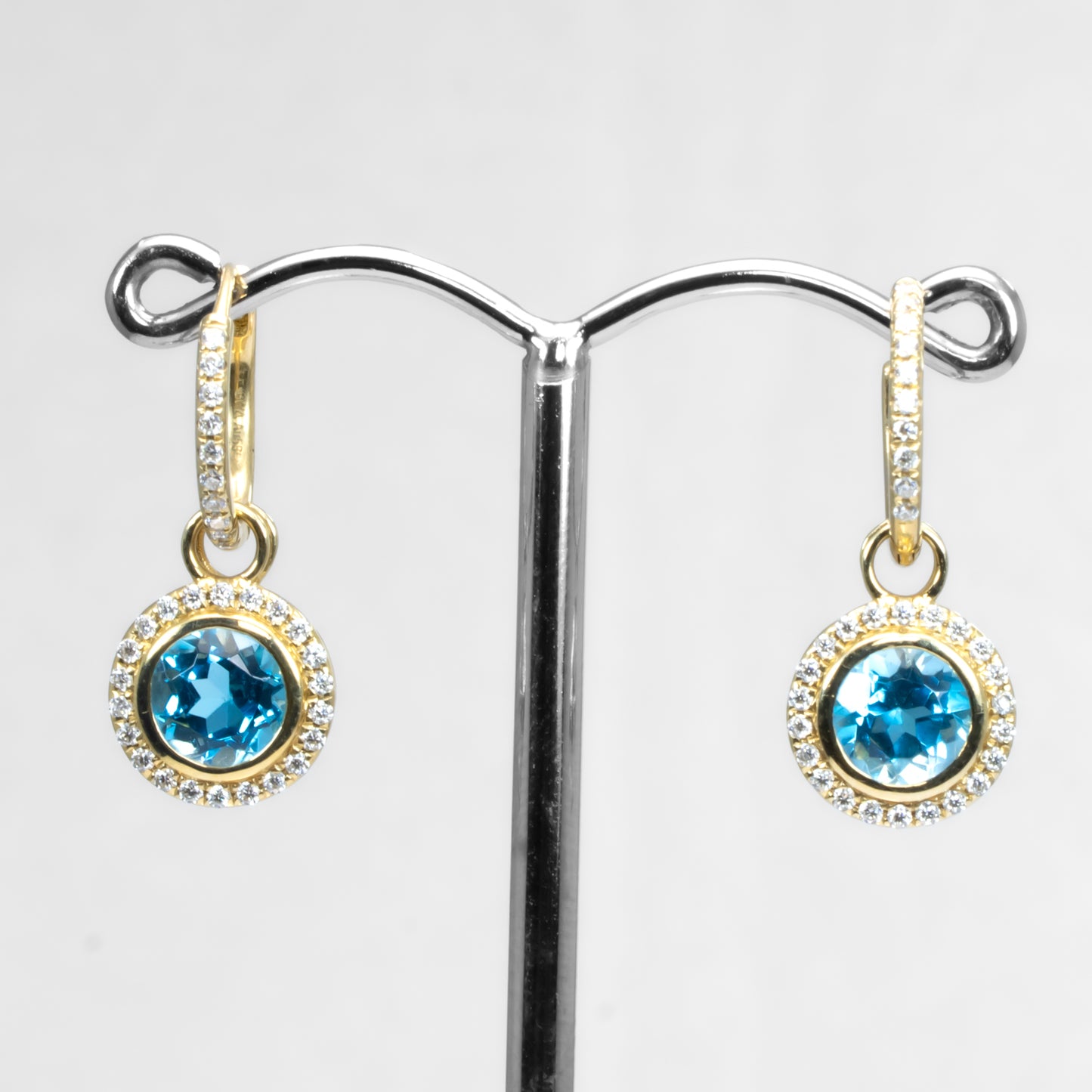 Yellow gold Swiss blue topaz earrings in white background