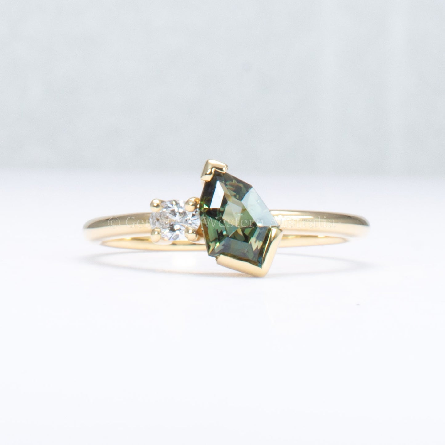 toi et moi teal sapphire gold ring in gray background