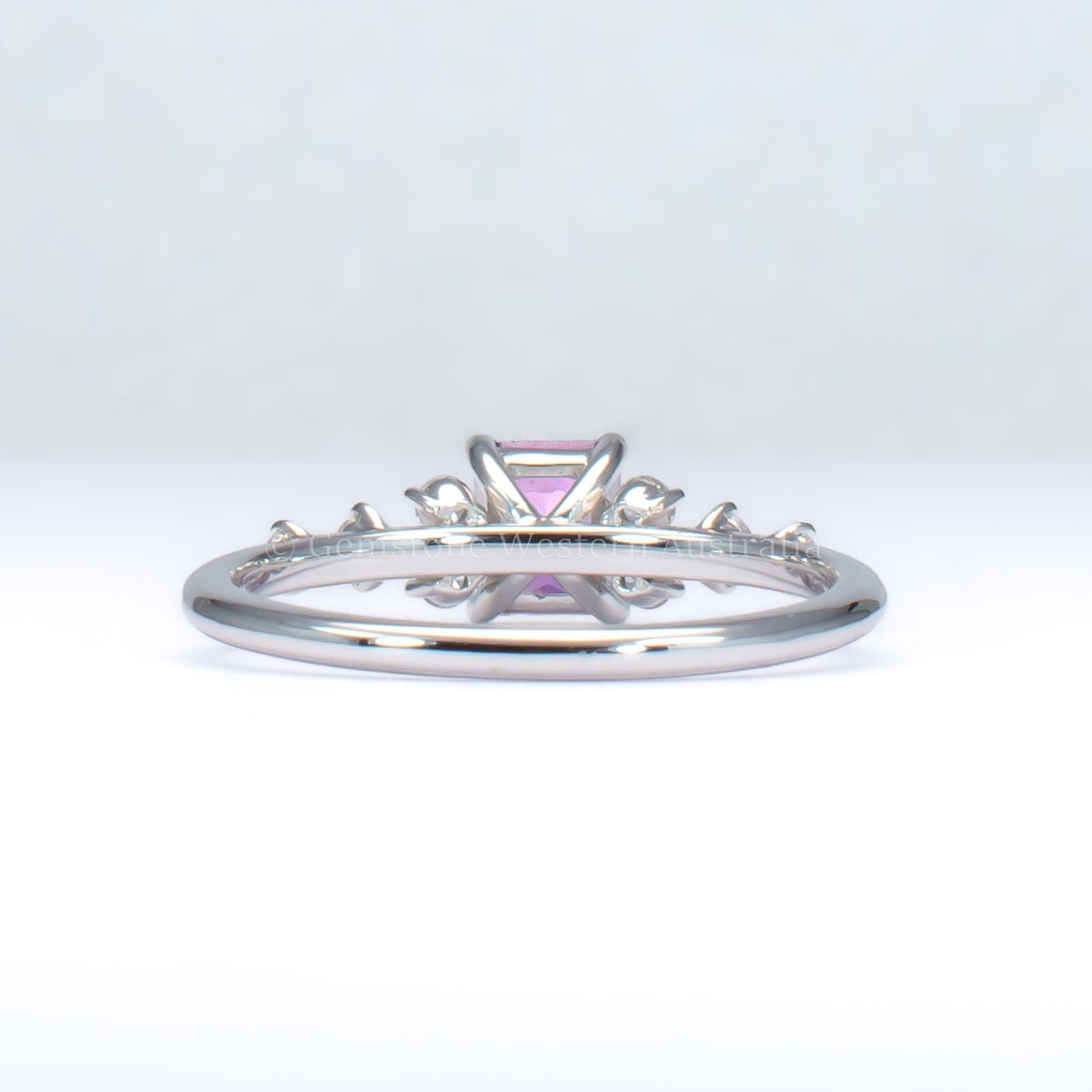back view of platinum pink sapphire ring with natural diamonds in gray background