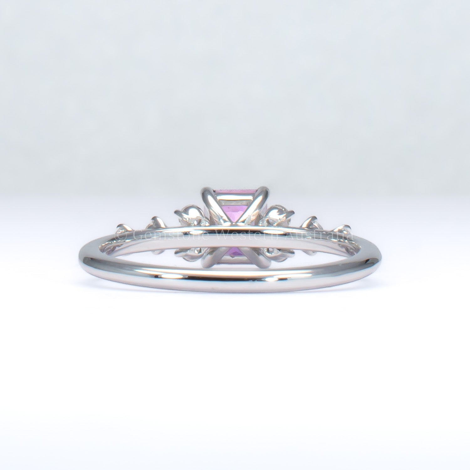 back view of platinum pink sapphire ring with natural diamonds in gray background