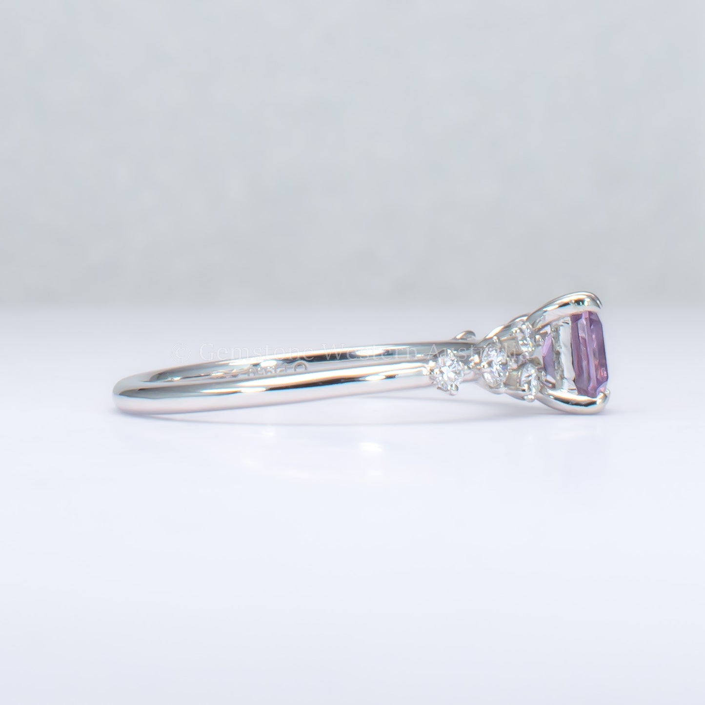 side view of platinum pink sapphire ring with natural diamonds in gray background