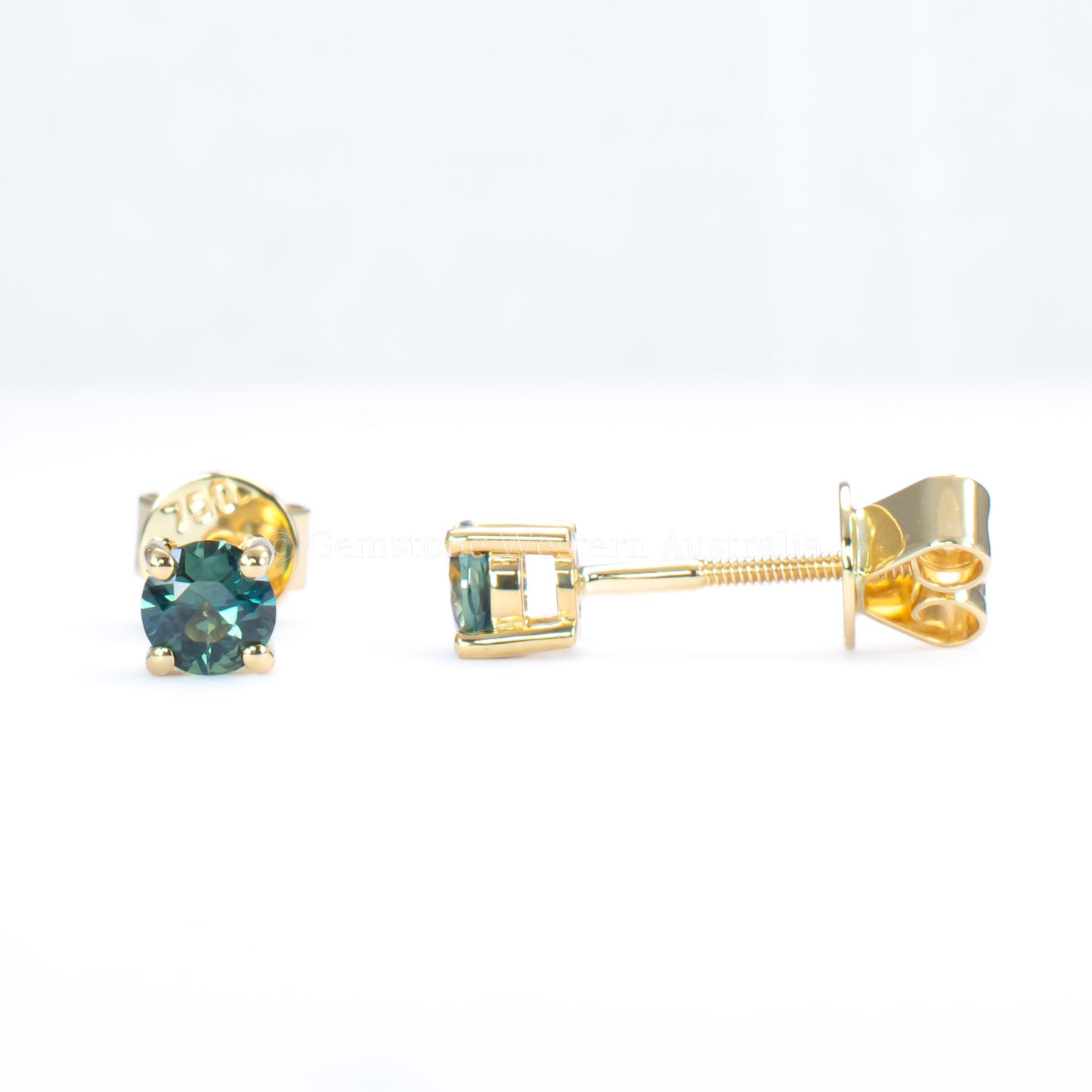 front and side view of Australian teal blue sapphire gold stud earrings in gray background