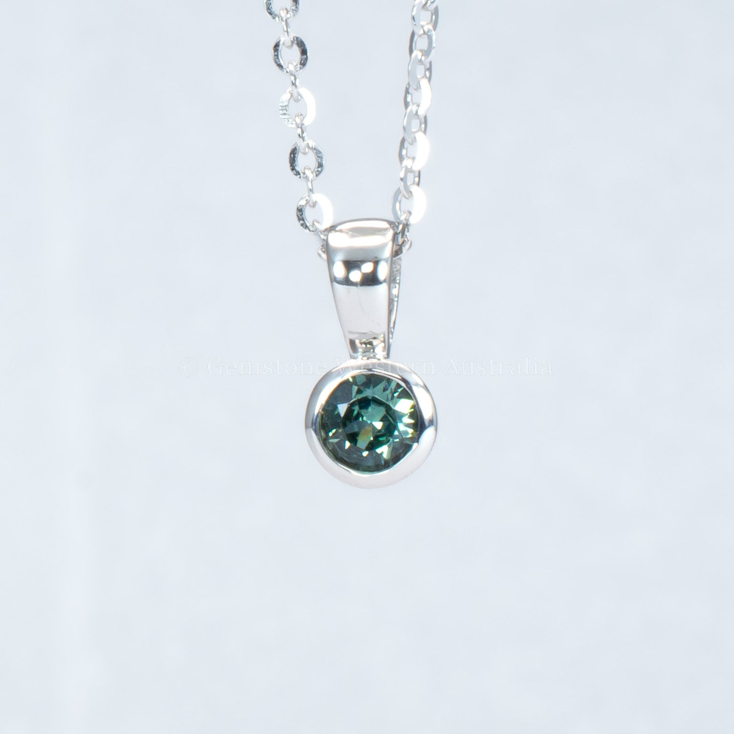 Australian teal sapphire platinum pendant in gray background