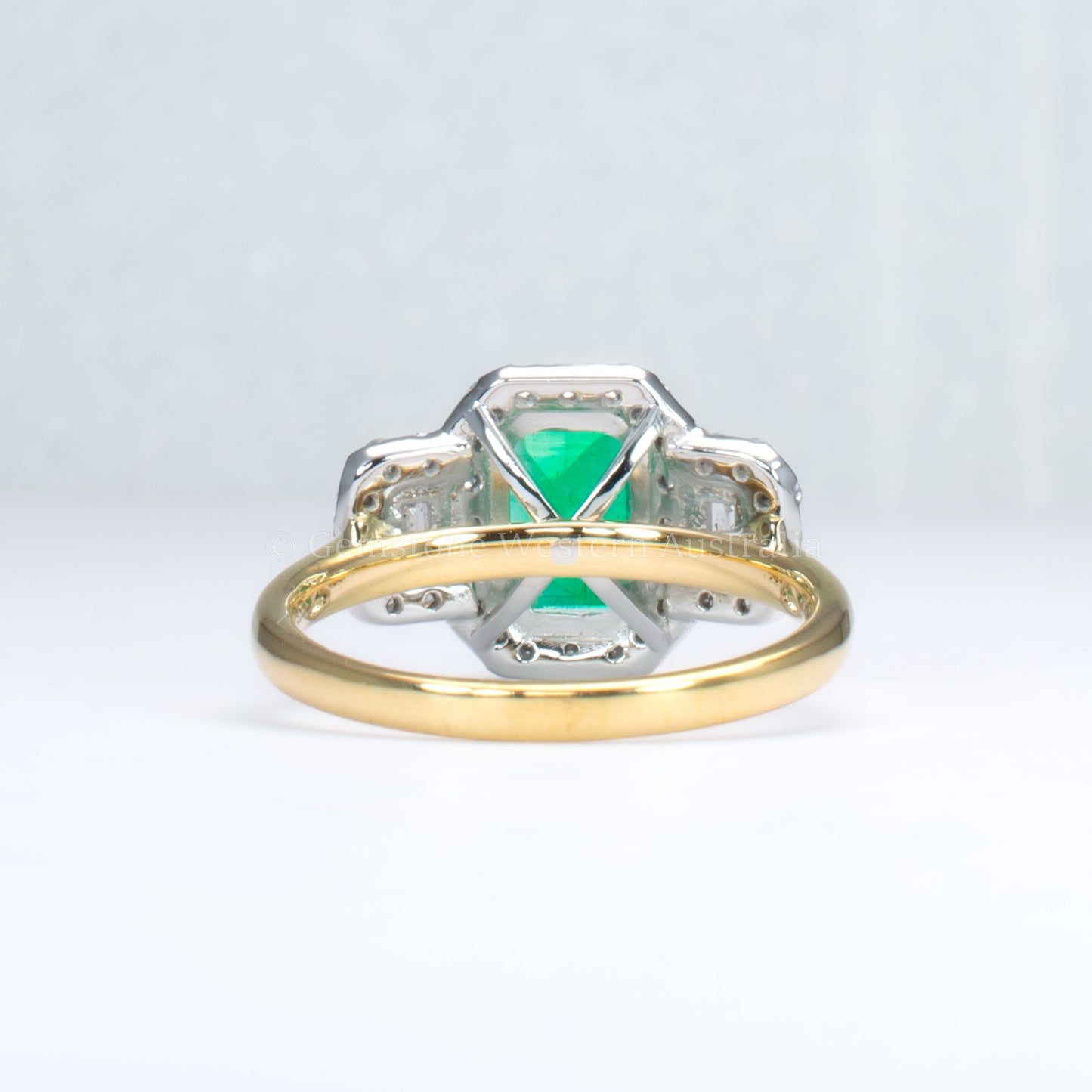 Elongated Colombian Emerald Three-Stone Halo Ring in Platinum and Gold