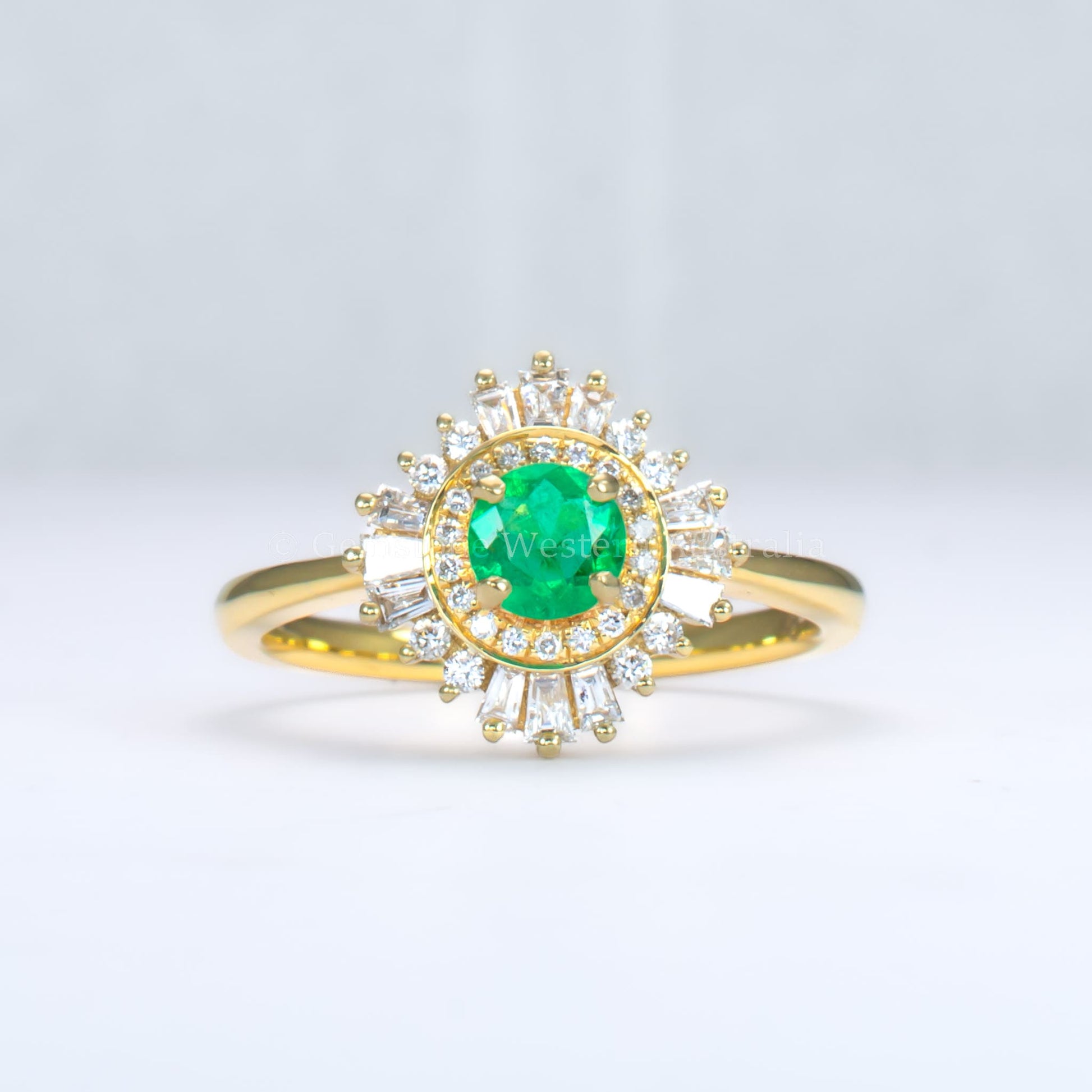 emerald Art Deco ring with diamond halo in light gray background