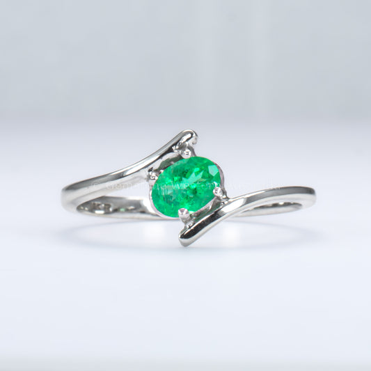white gold ring with natural Colombian emerald in light gray background