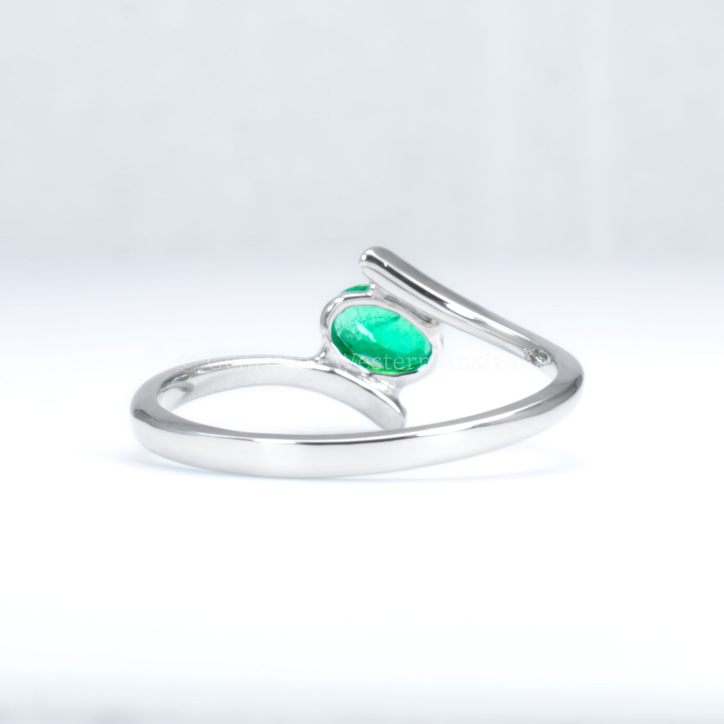 back view of white gold ring with natural Colombian emerald in light gray background