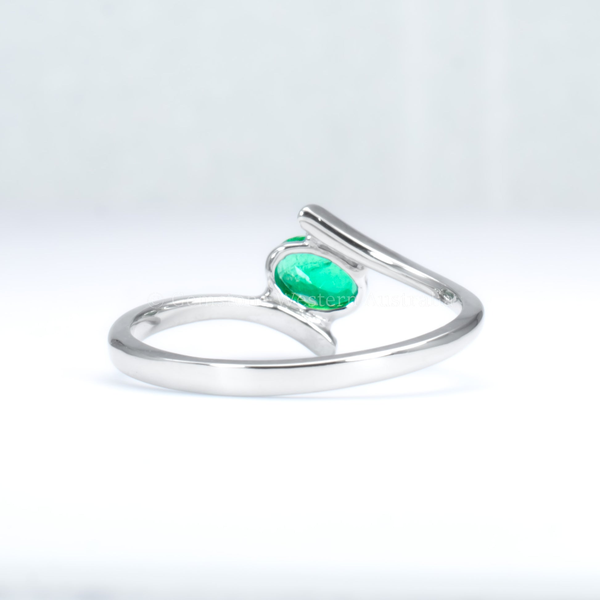 back view of white gold ring with natural Colombian emerald in light gray background