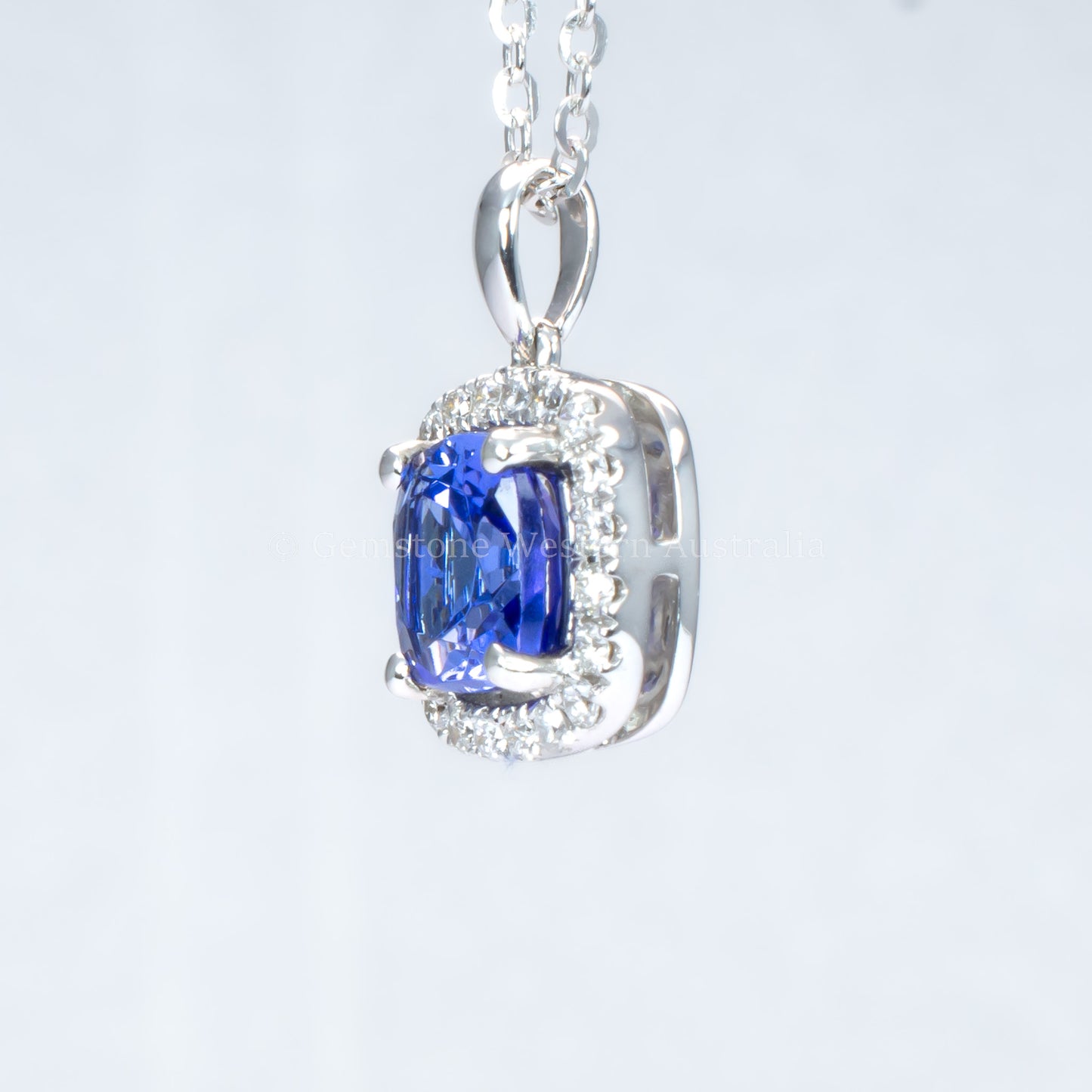 side view of Natural tanzanite diamond pendant in white gold in gray background