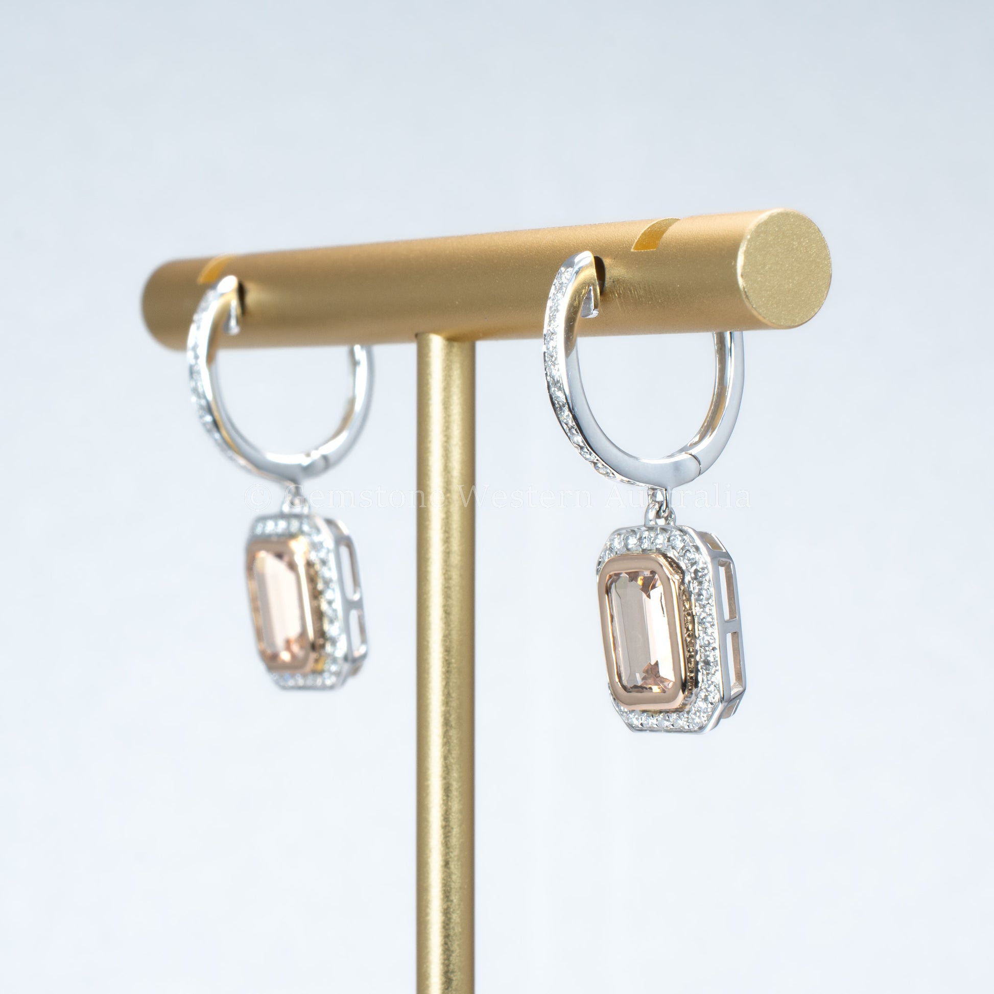 side view of morganite and diamonds gold earrings in light gray background