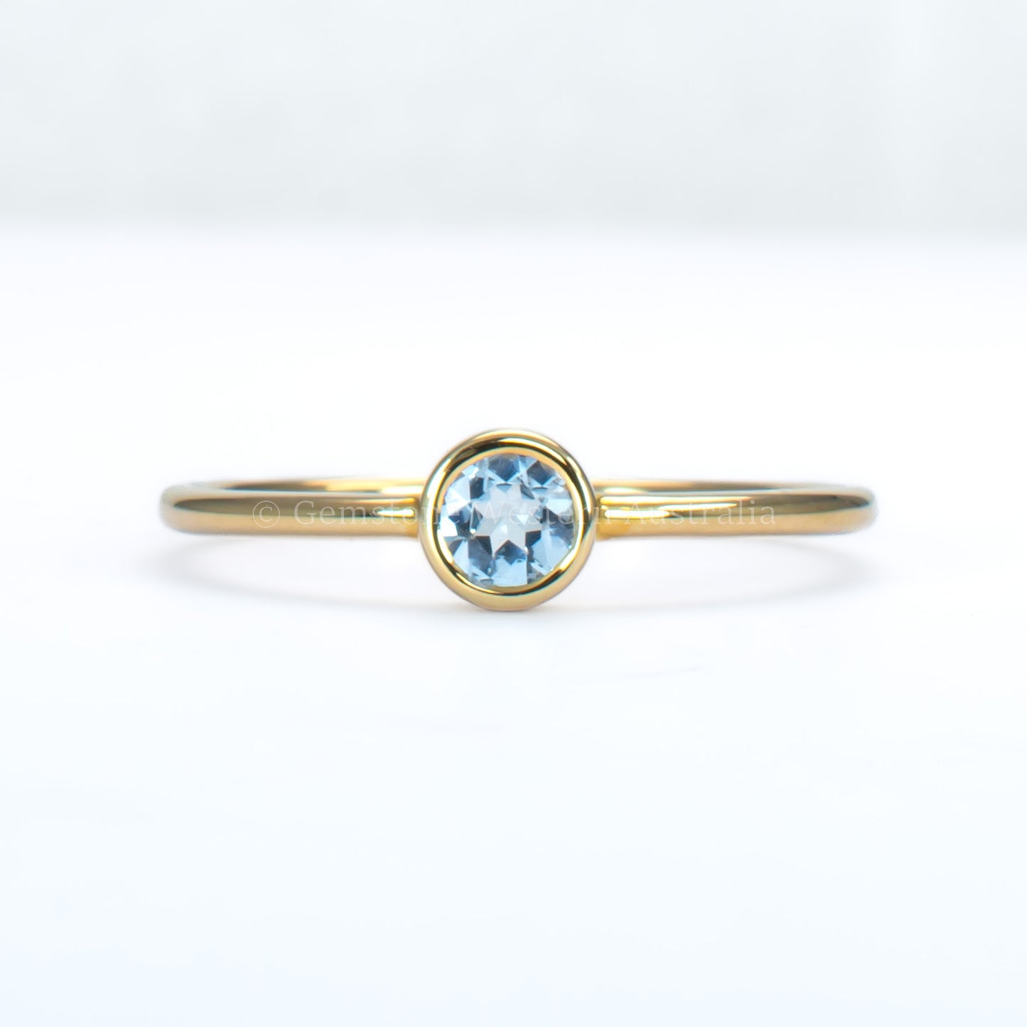aquamarine yellow gold ring in light gray background