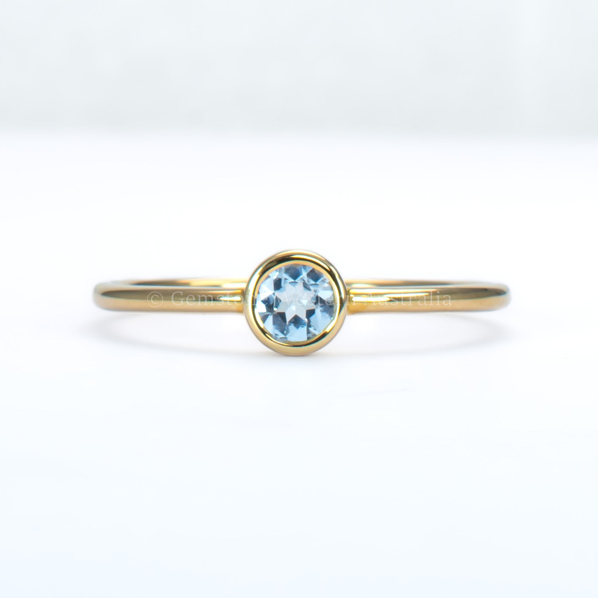 aquamarine yellow gold ring in light gray background