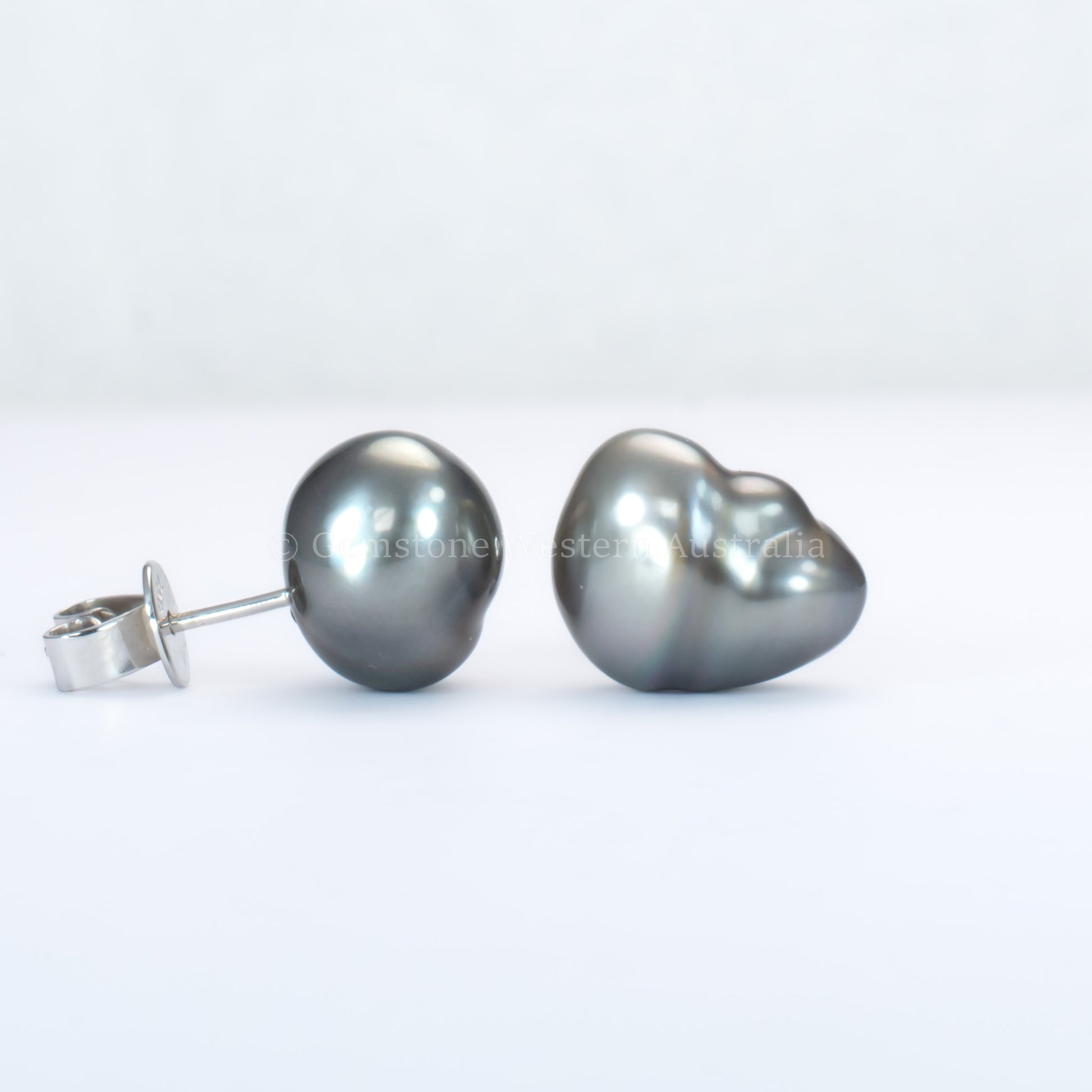 side and front view of Tahitian pearl stud earrings on a gray background