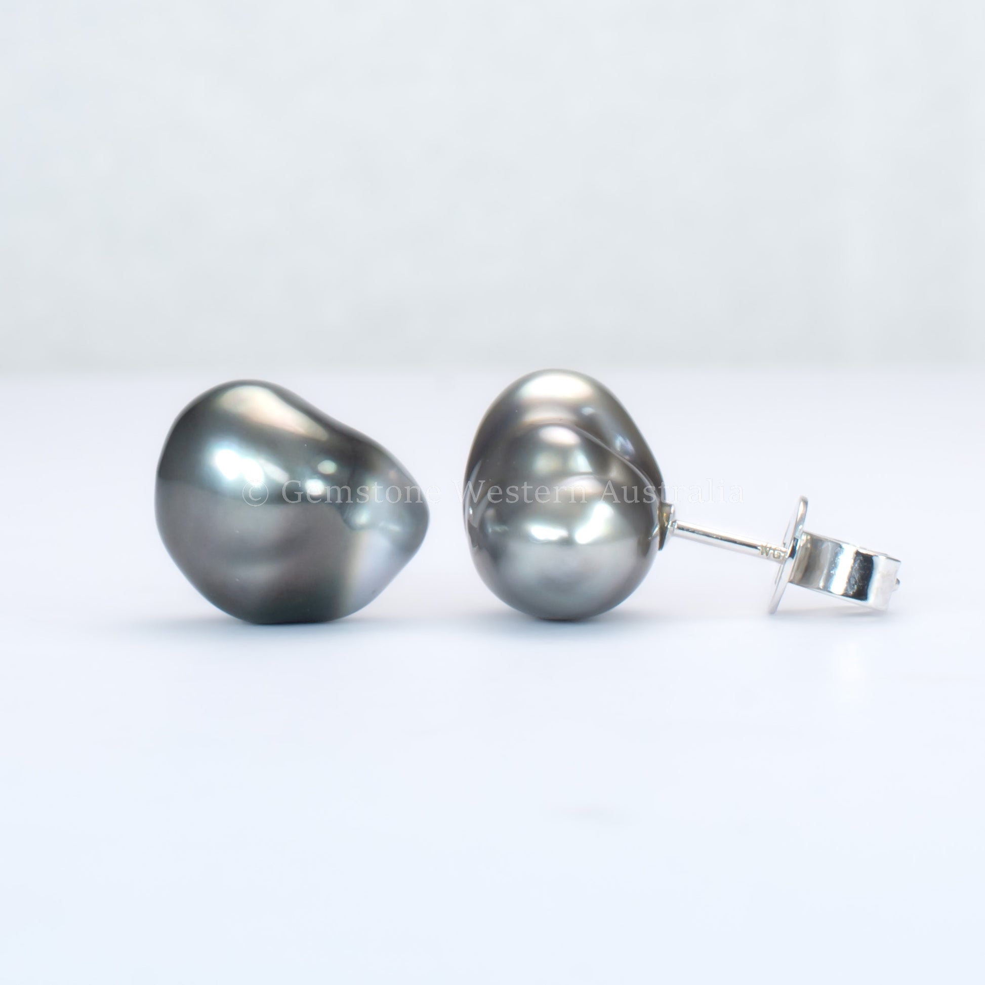 Pair of tahitian pearl earrings on a white background