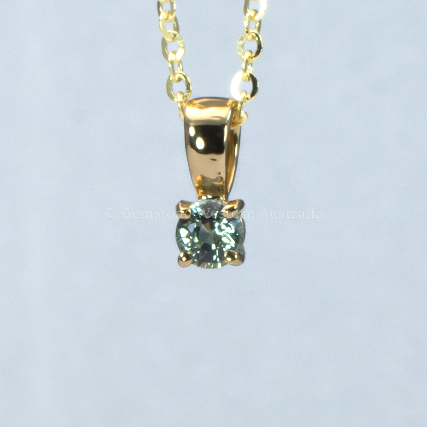 yellow gold alexandrite pendant in gray background