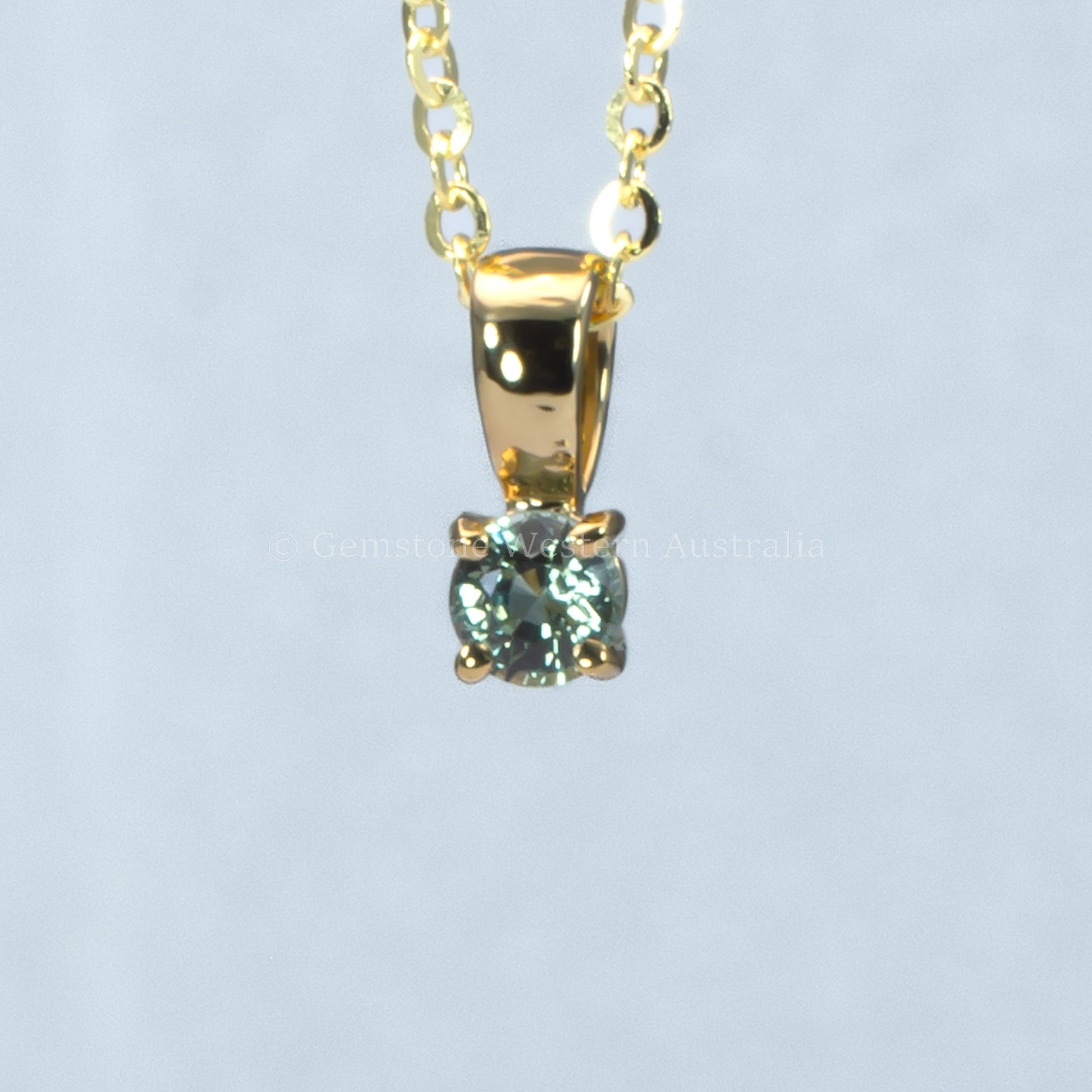 yellow gold alexandrite pendant in gray background