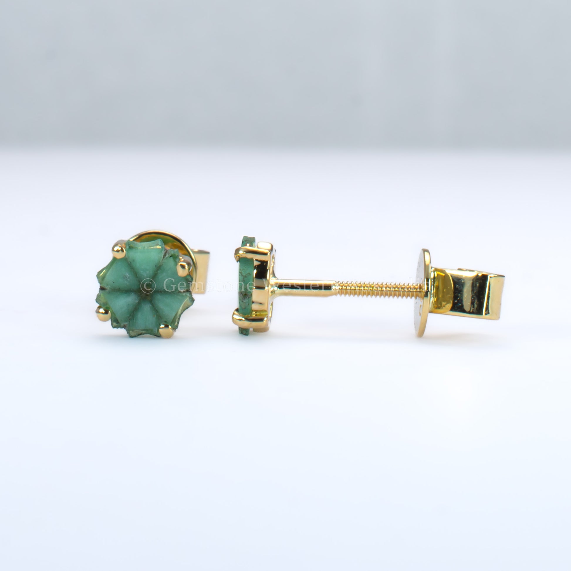 front and side view of pair of natural emerald stud earrings set in  18K yellow gold
