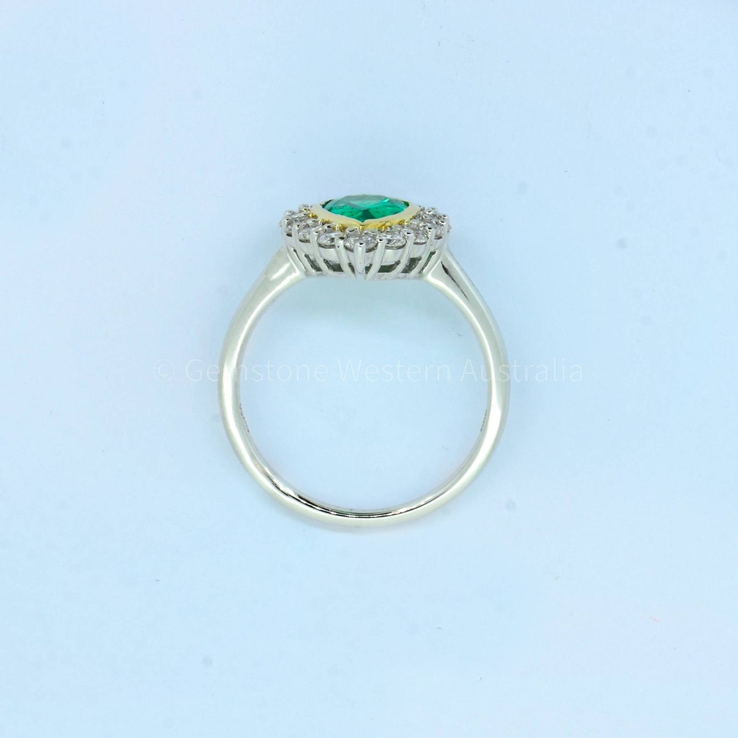 Bezel Set Emerald in a Diamond Halo Ring in 18K Gold