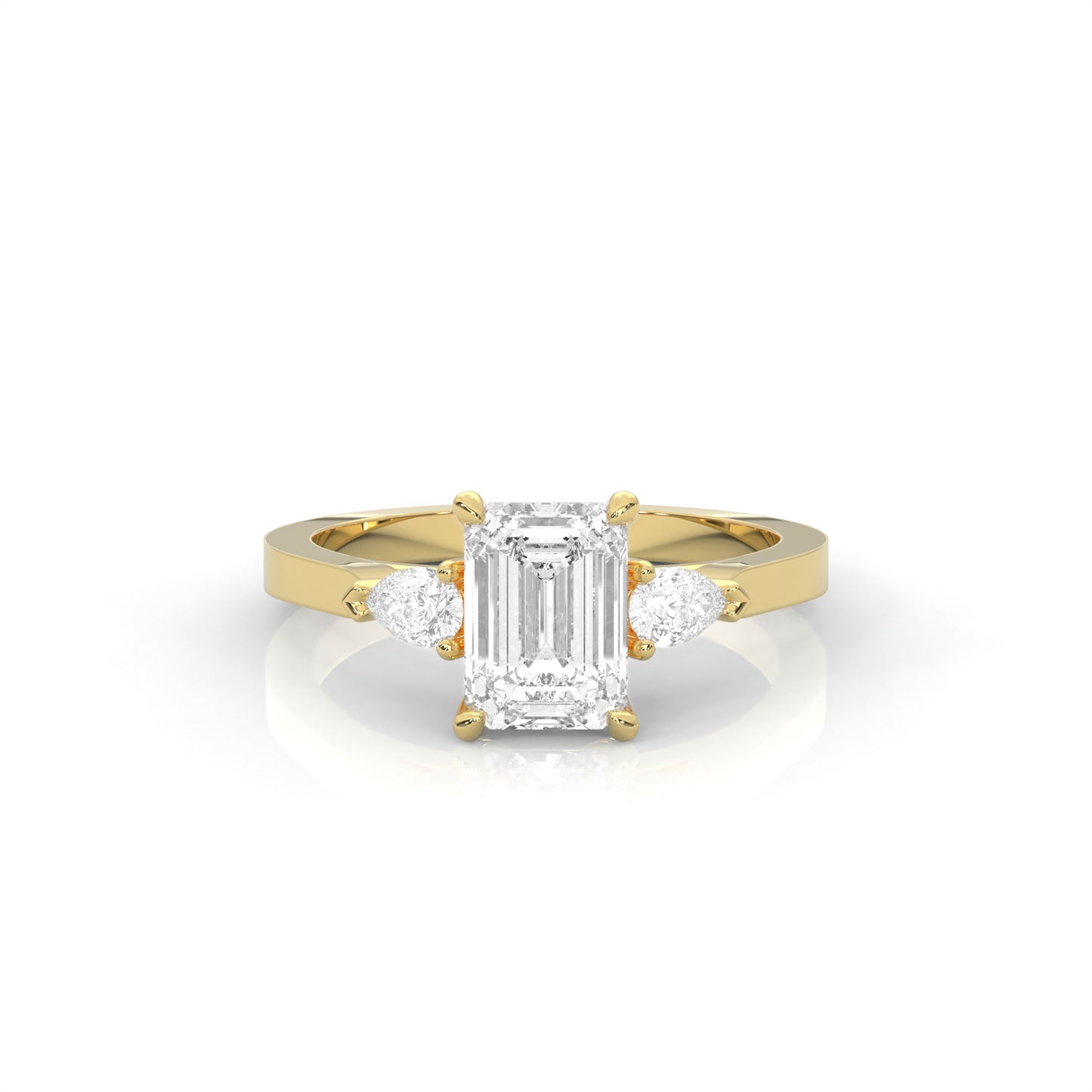 yellow gold ring with emerald-cut diamond and pear diamonds on the sides against a white background